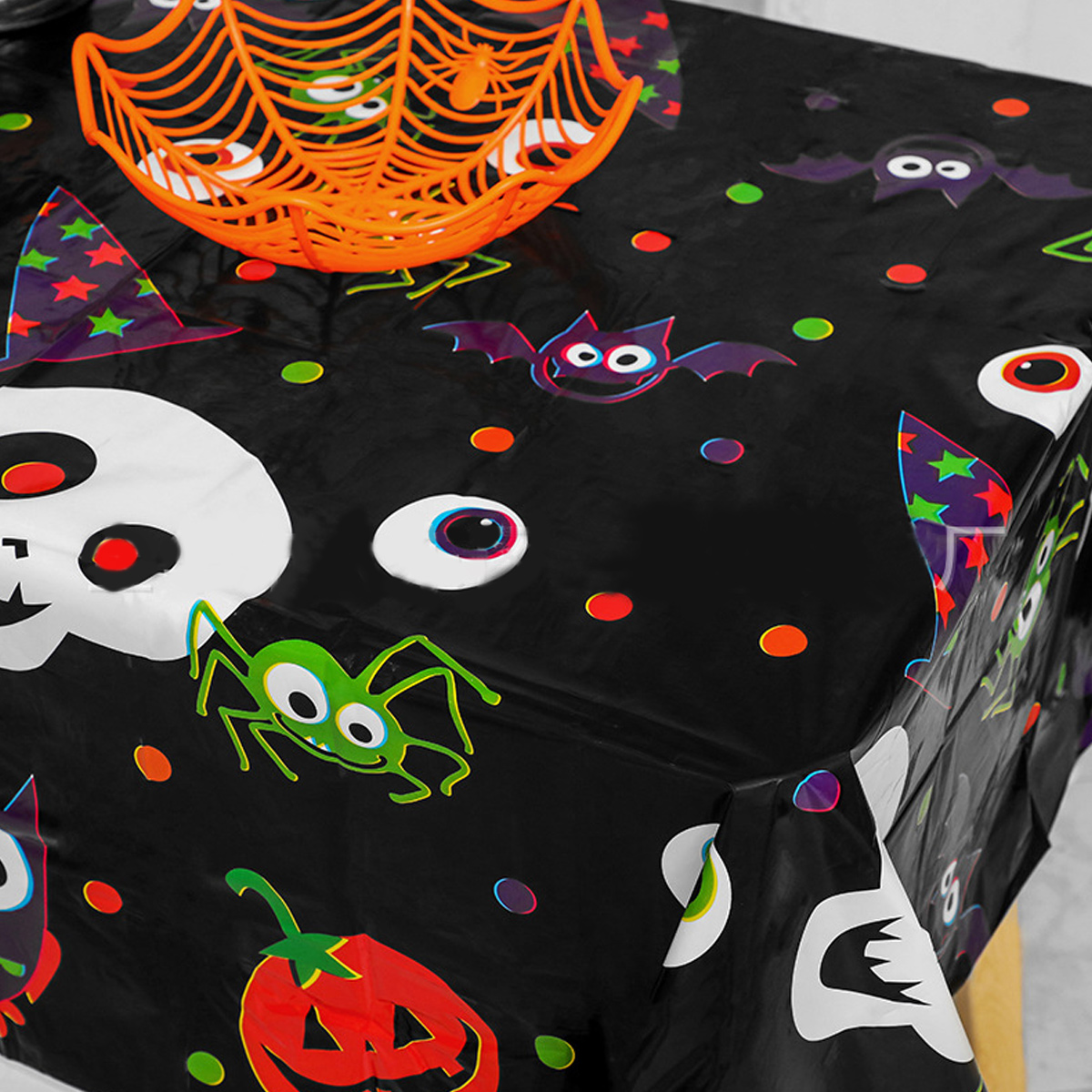 Halloween-Tischdecke mit gruseligen Dekorationen: Fledermäuse, Kürbisse und Spinnen.