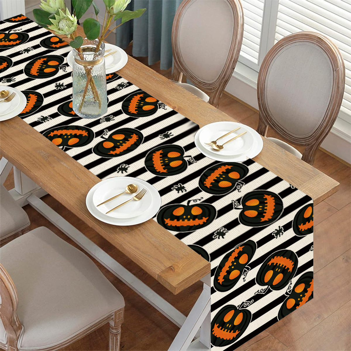 Halloween-Tischläufer mit Kürbissen und schwarzen Streifen, mit Tellern und Besteck.