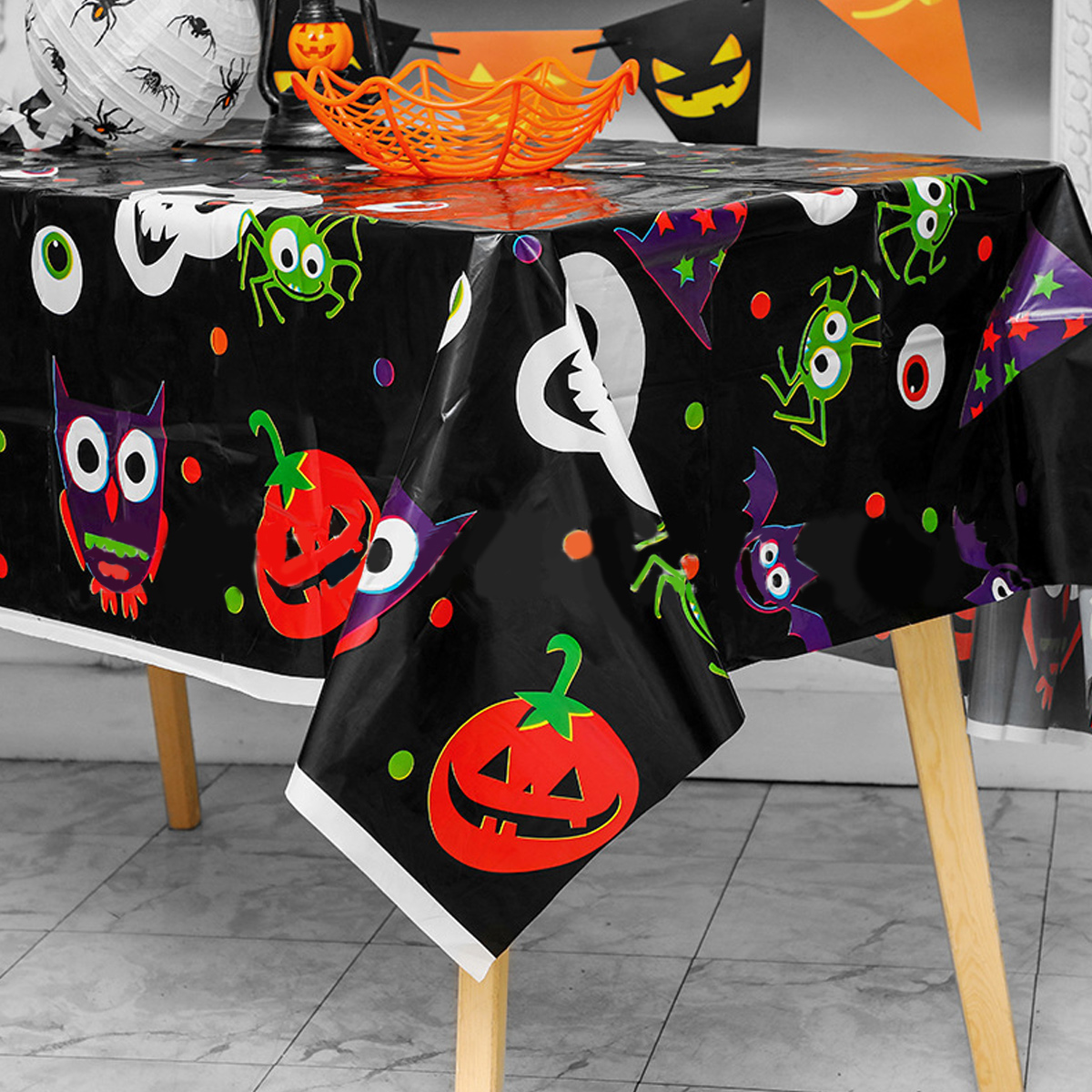 Halloween-Tischdeko. Schwarze Tischdecke mit Halloween-Cartoonfiguren und Dekorationen.