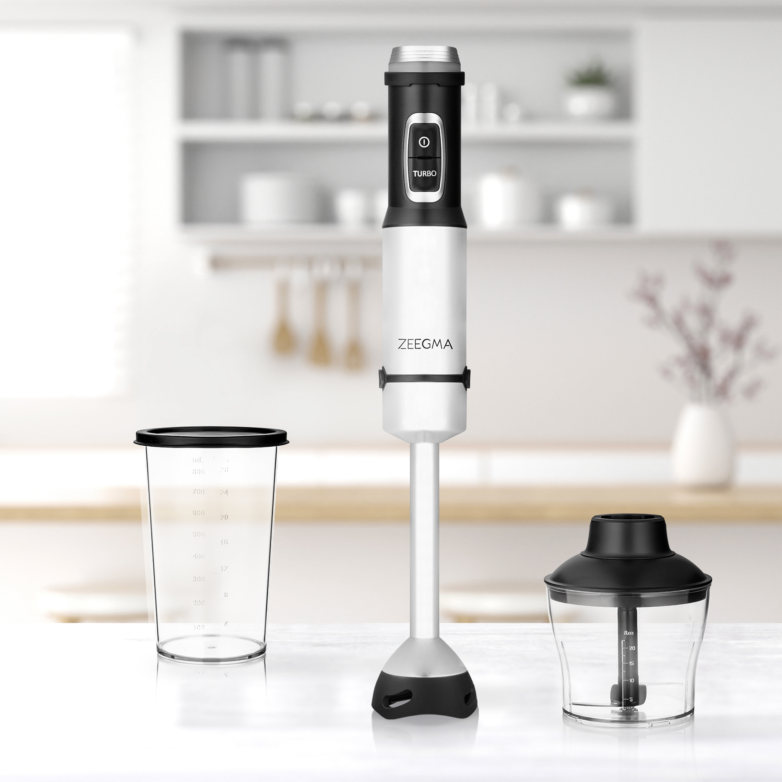 Biało-czarny blender ręczny z akcesoriami na stole, tło kuchenne.