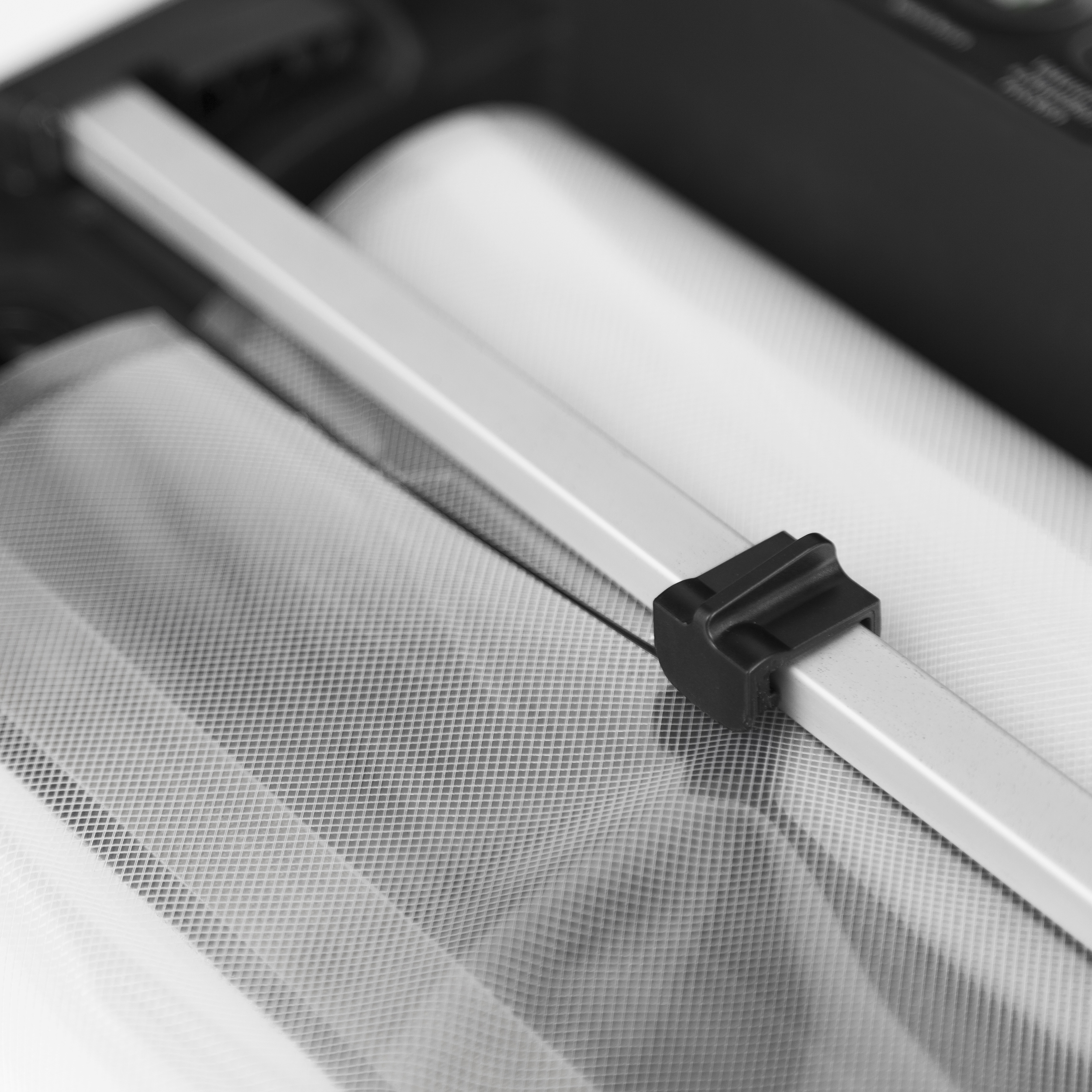 In einer Vakuumversiegelungsmaschine. Silberne Metallstangen und weißes Netzplastik.