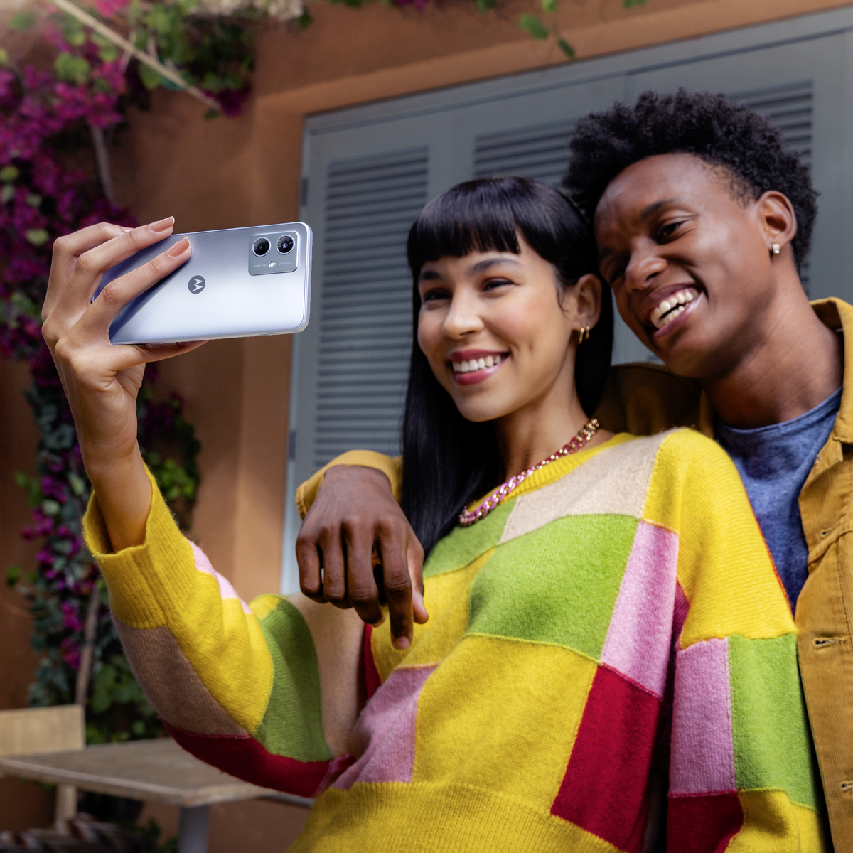 Dwie osoby robiące sobie selfie telefonem na zewnątrz.