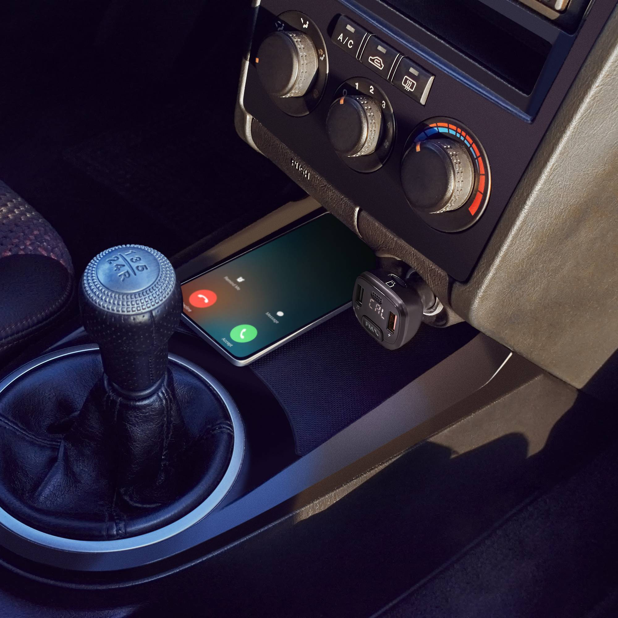 Interior de coche con teléfono cargando, palanca de cambios y salpicadero visibles.