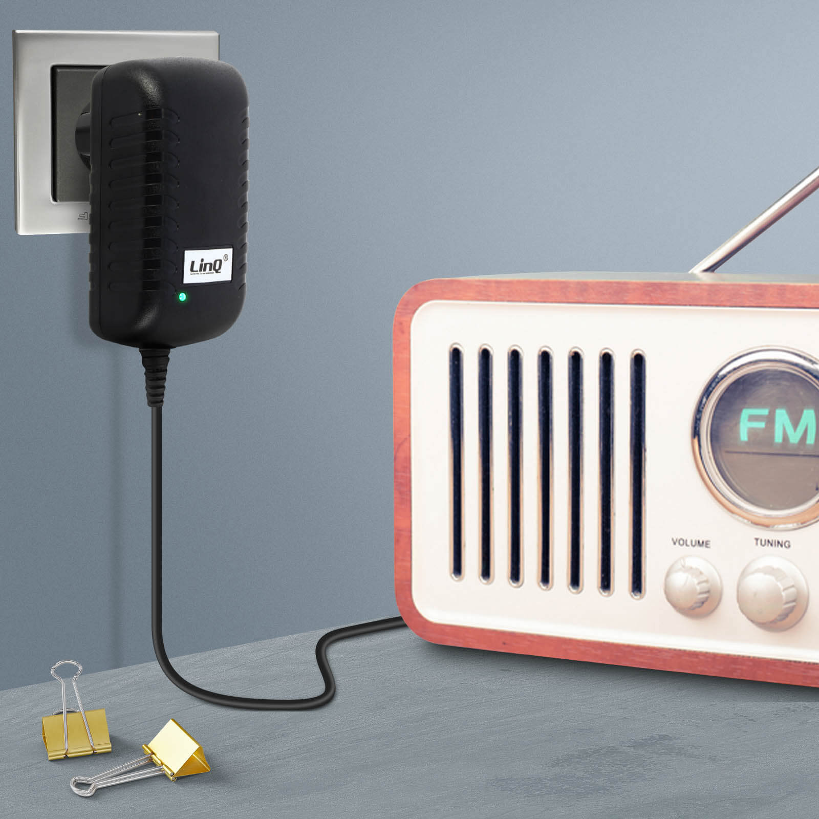 Caricabatterie nero collegato al muro, collegato a una radio retrò.