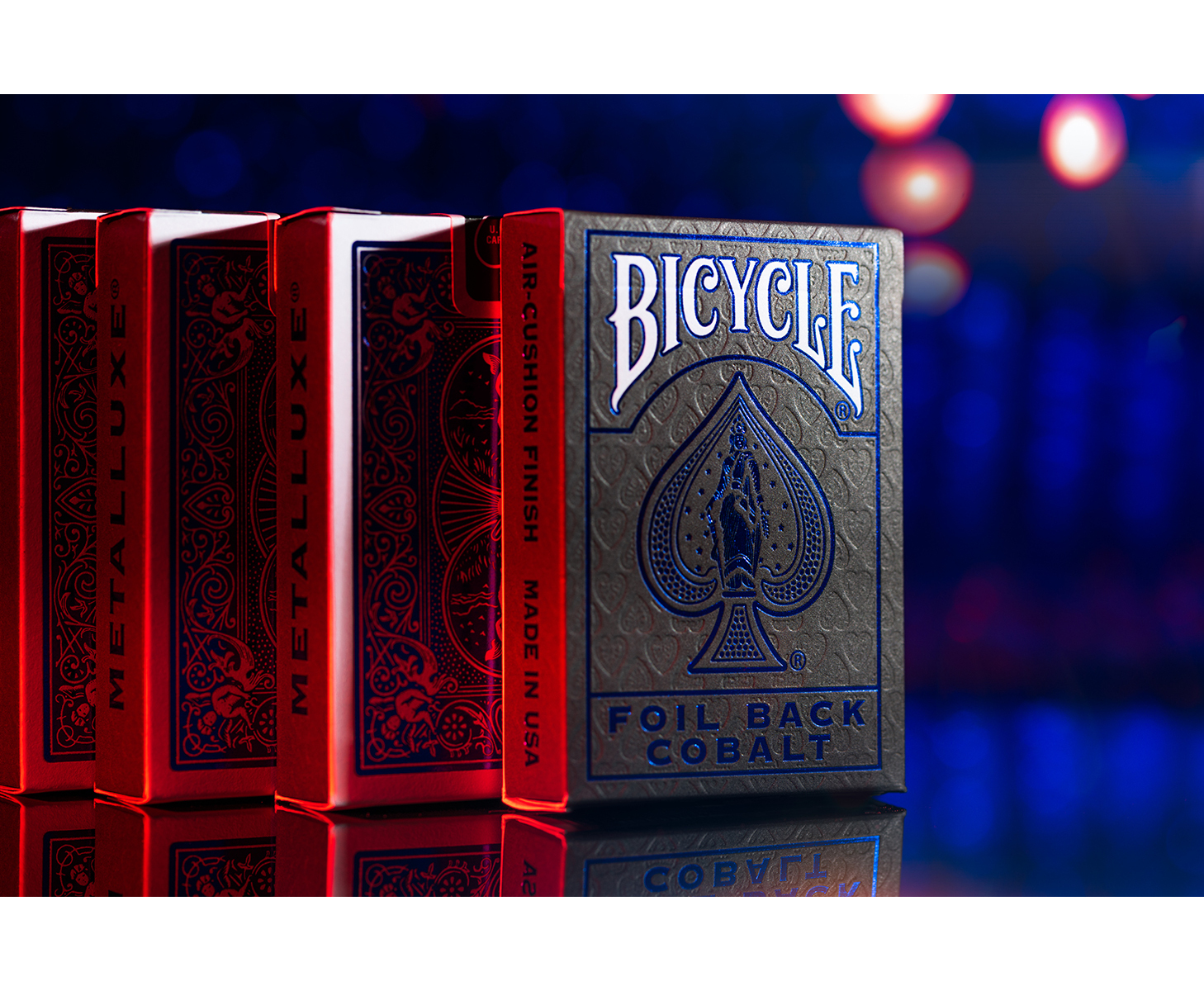 Ein Kartenspiel von Bicycle mit dunkelblauem Design und roter Verpackung auf reflektierender Oberfläche.