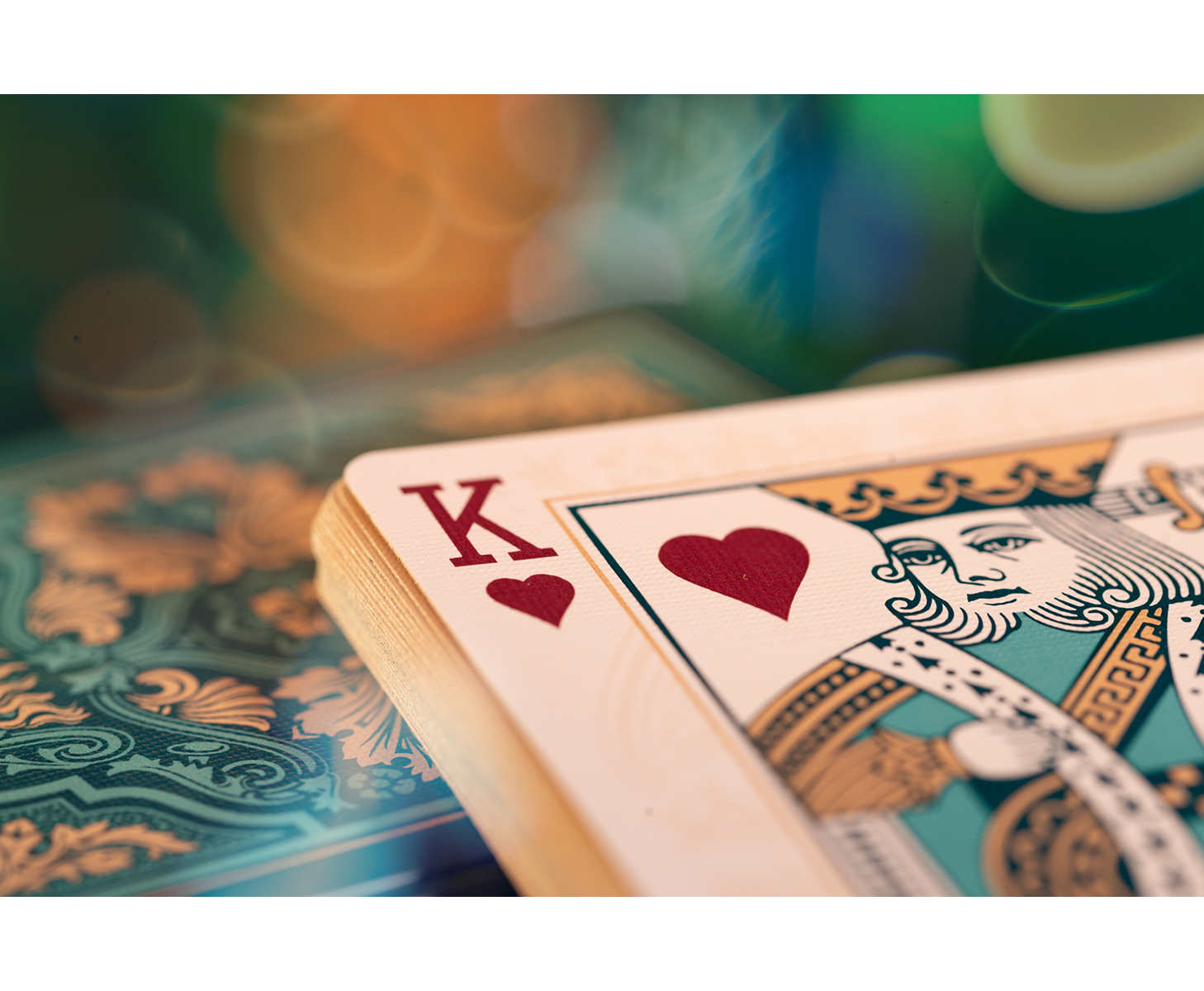 Nahaufnahme einer Spielkarte: König der Herzen, mit grünem Bokeh-Hintergrund.