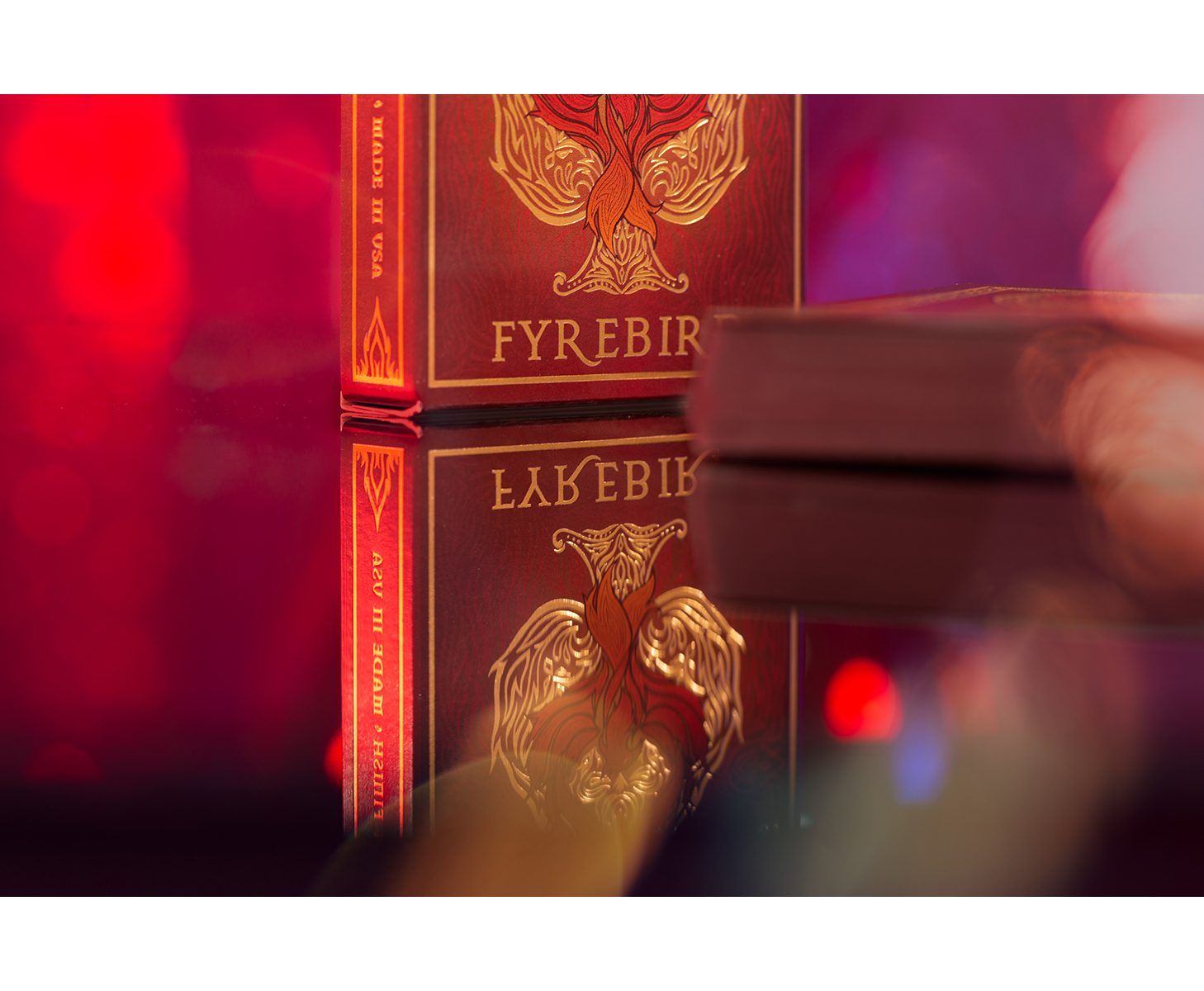 Nahaufnahme eines Buchcovers mit goldenem Design und Text, vor rotem Hintergrund.
