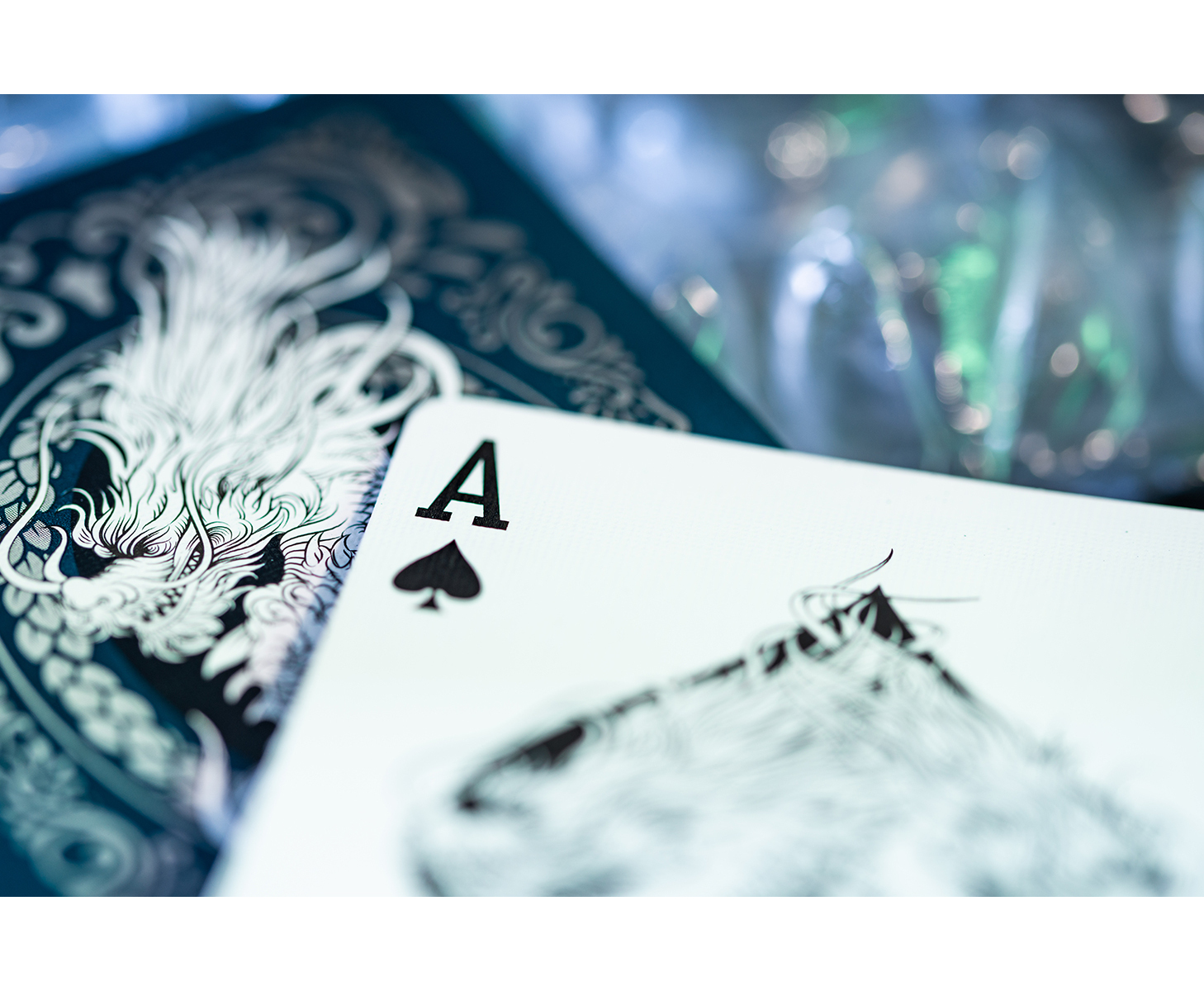 Spielkarte Pik-Ass, Drachendesign auf der Rückseite, blauer Hintergrund.