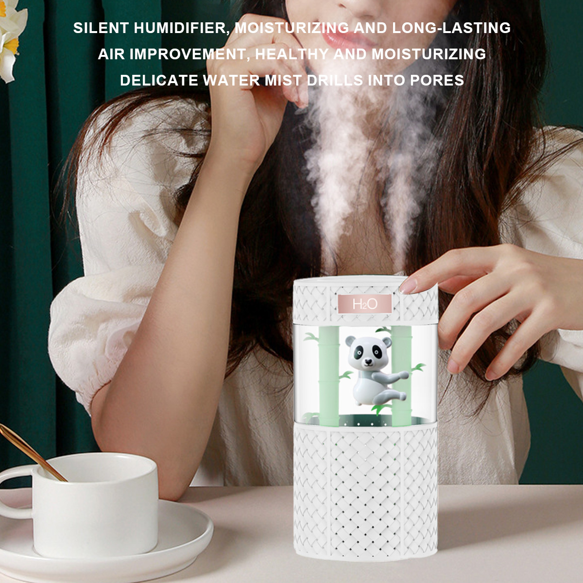 Weißer Aromadiffusor mit Panda-Illustration. Nebel kommt heraus. Weiße Tasse und Löffel davor.