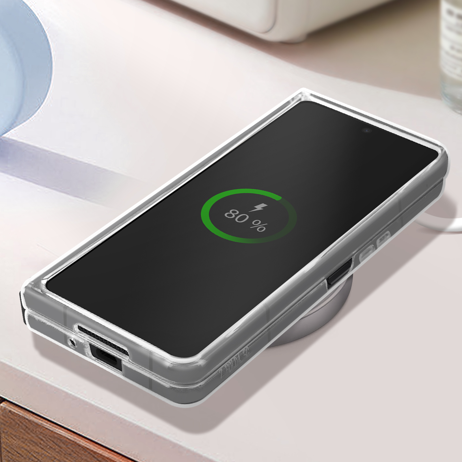 Telefono su caricatore wireless. Schermo mostra 80%. Sfondo scrivania bianco.