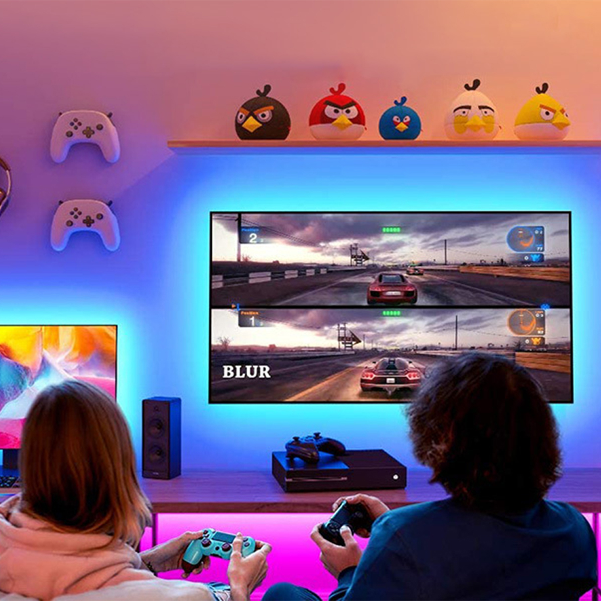 Leute spielen ein Spiel auf einem Fernseher mit LED-Streifenlichtern darum herum.