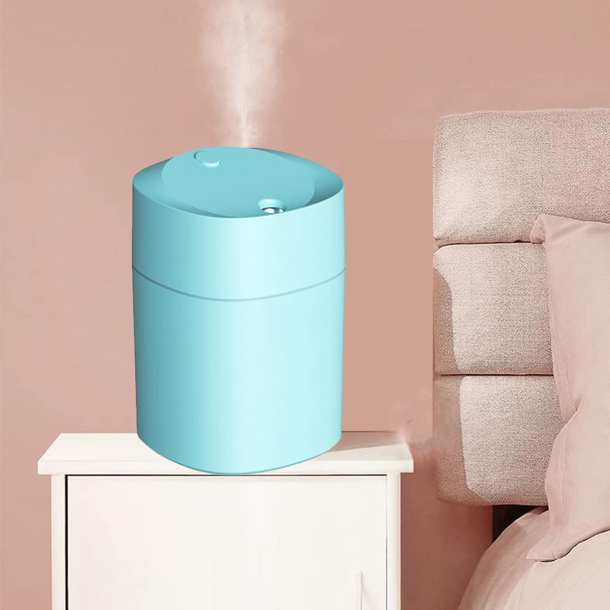 Blauer Luftbefeuchter auf weißem Tisch, rosa Hintergrund und Bett.