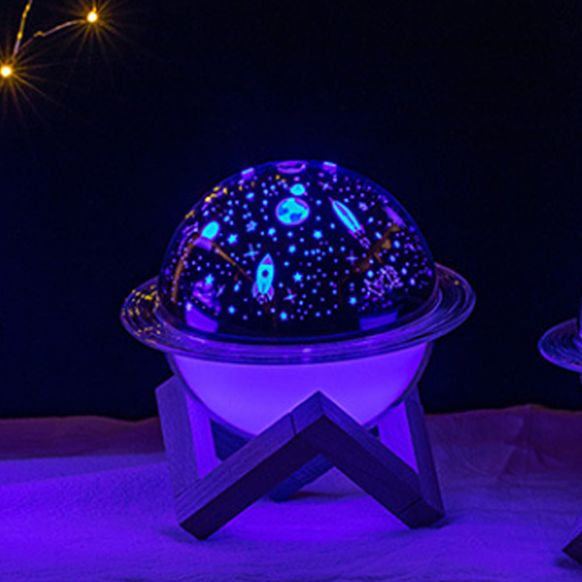 Eine Planetariumslampe mit Galaxienprojektion. Sie steht auf einem Holzsockel, mit dunklem Hintergrund.