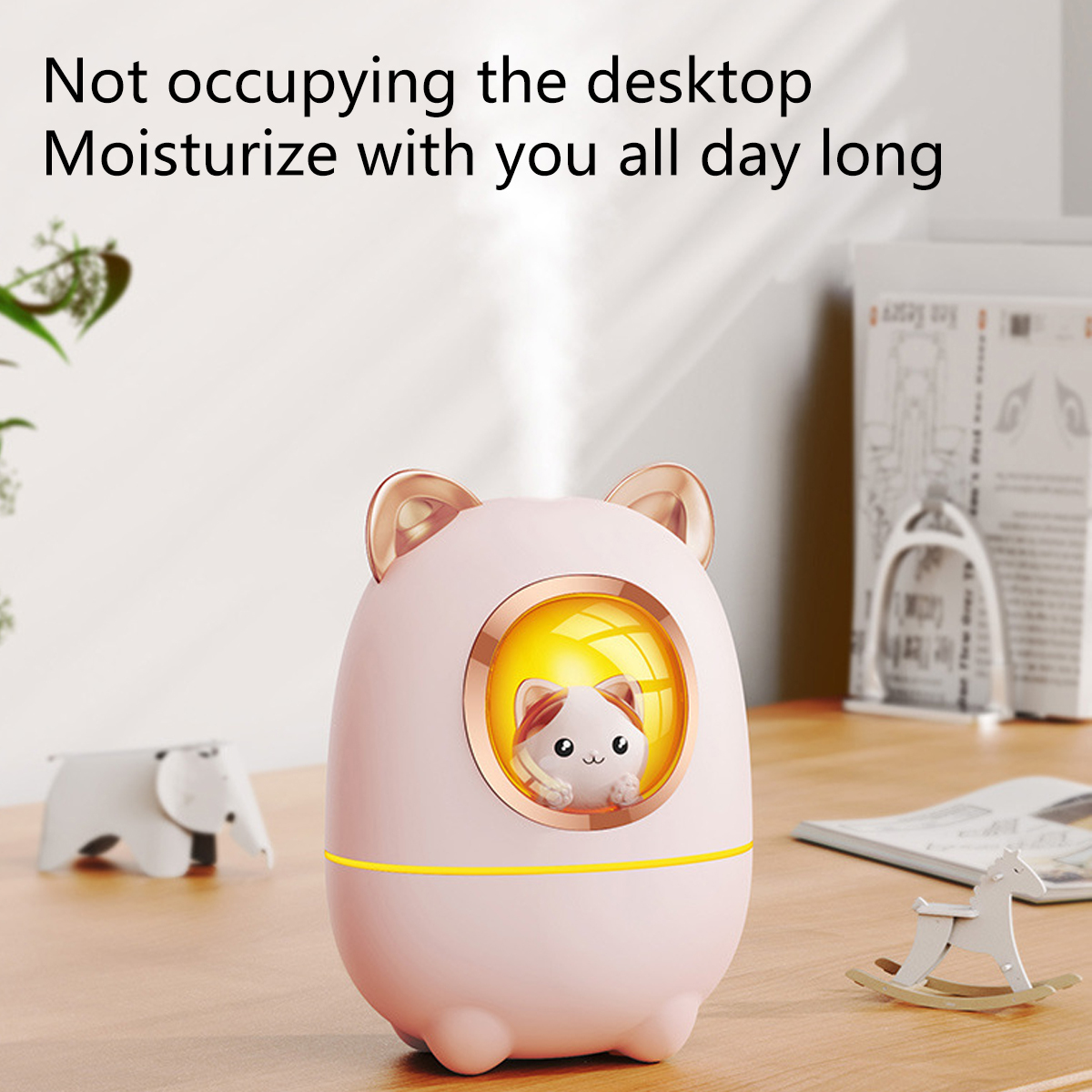 Rosa katzenförmiger Luftbefeuchter auf dem Schreibtisch, mit Katzenbild vorne.