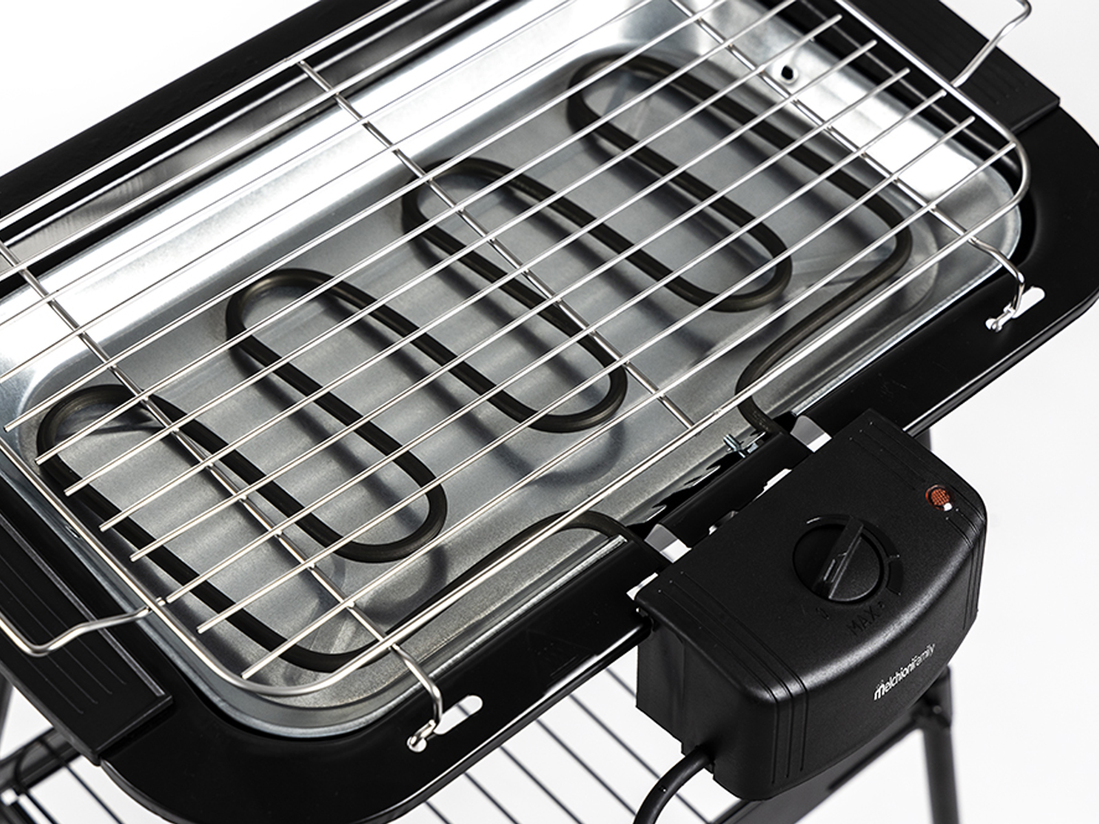Ein Elektrogrill mit Heizelementen und einem Drehknopf. Der Grill steht auf einer weißen Oberfläche.