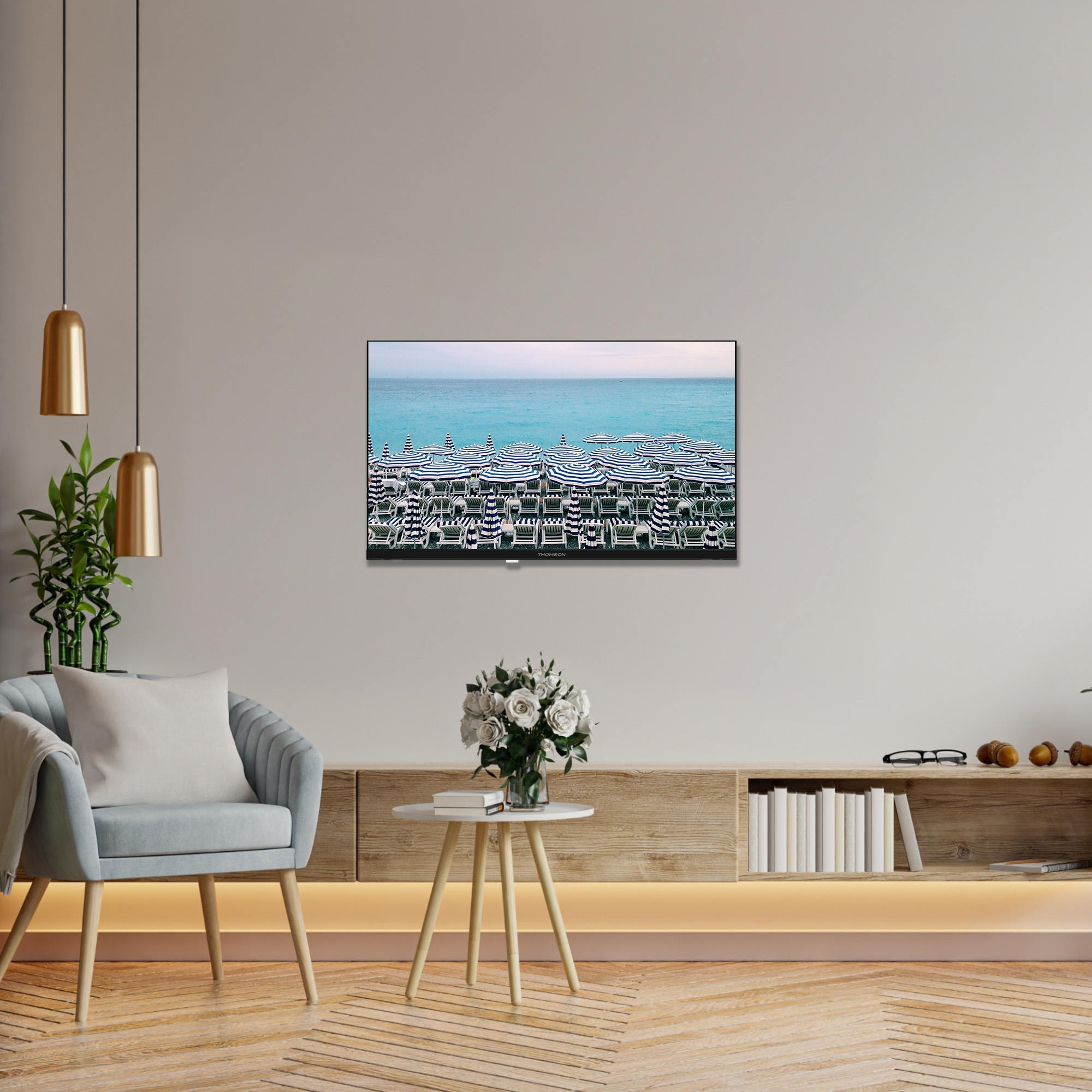 Scena na plaży z paskowanymi parasolami. Telewizor na ścianie pokazuje tę samą scenę.