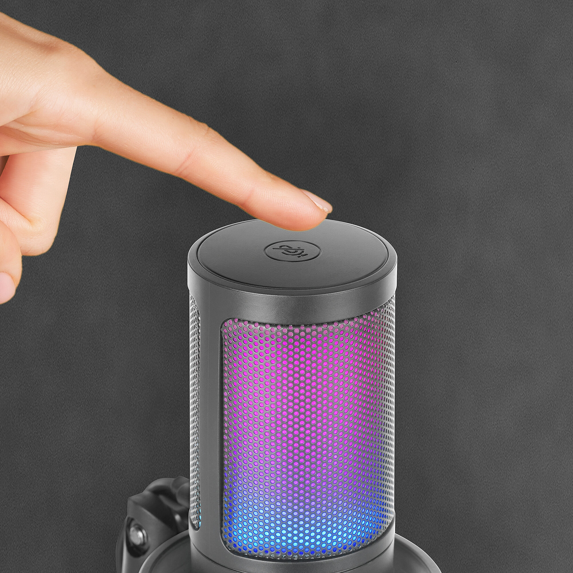Un dedo presiona un botón en un micrófono. El micrófono tiene una rejilla iluminada y colorida.