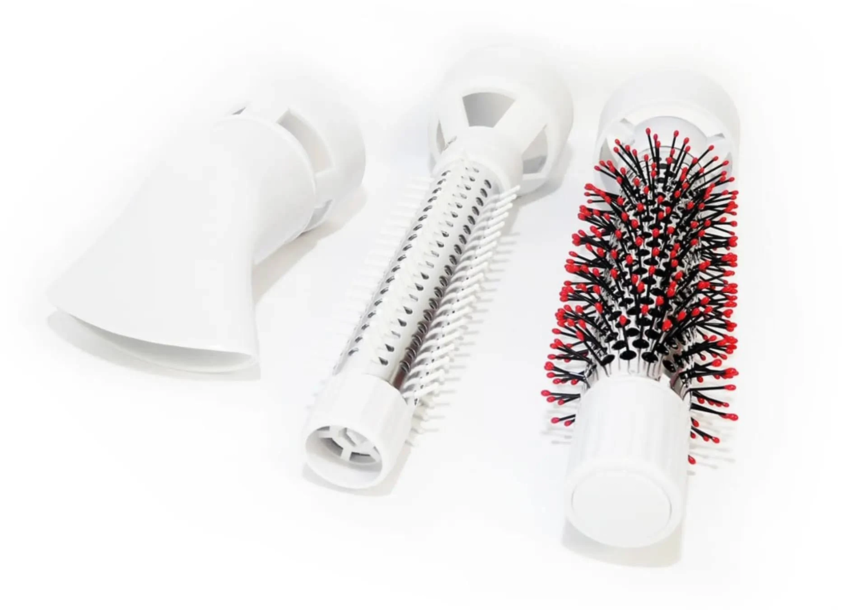 Trzy białe nasadki do suszarki na białym tle. Jedna ma czerwone włosie.
