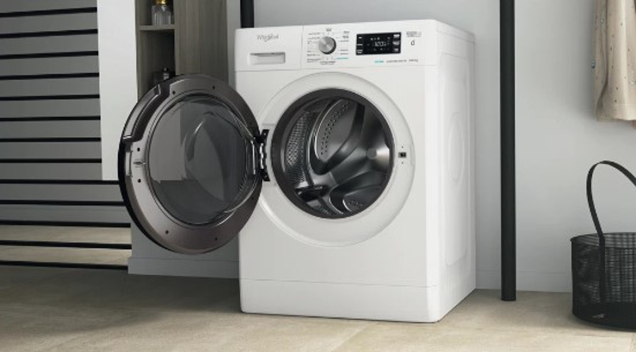 Una lavadora Whirlpool blanca con la puerta abierta, en un lavadero.