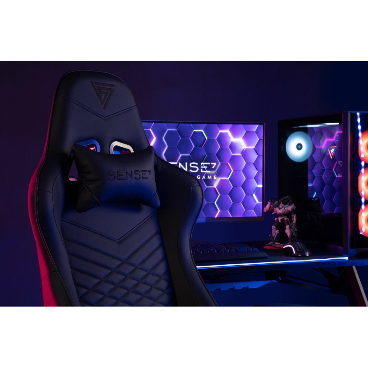 Gaming stoel met een zwarte zitting en rugleuning. De stoel heeft een hoofdkussen en staat in een gamekamer.