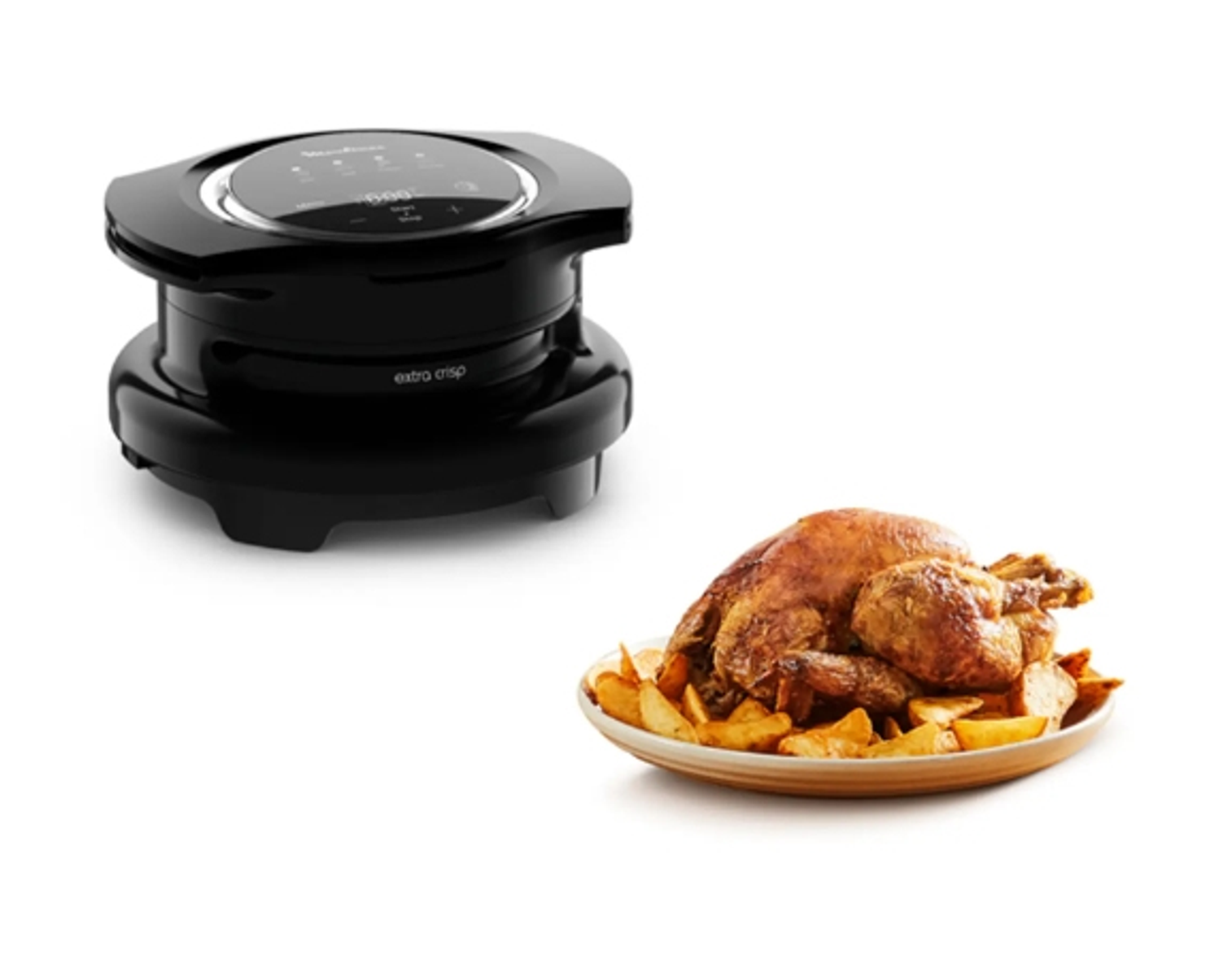 Freidora de aire negra y un pollo asado con patatas en un plato sobre fondo blanco.