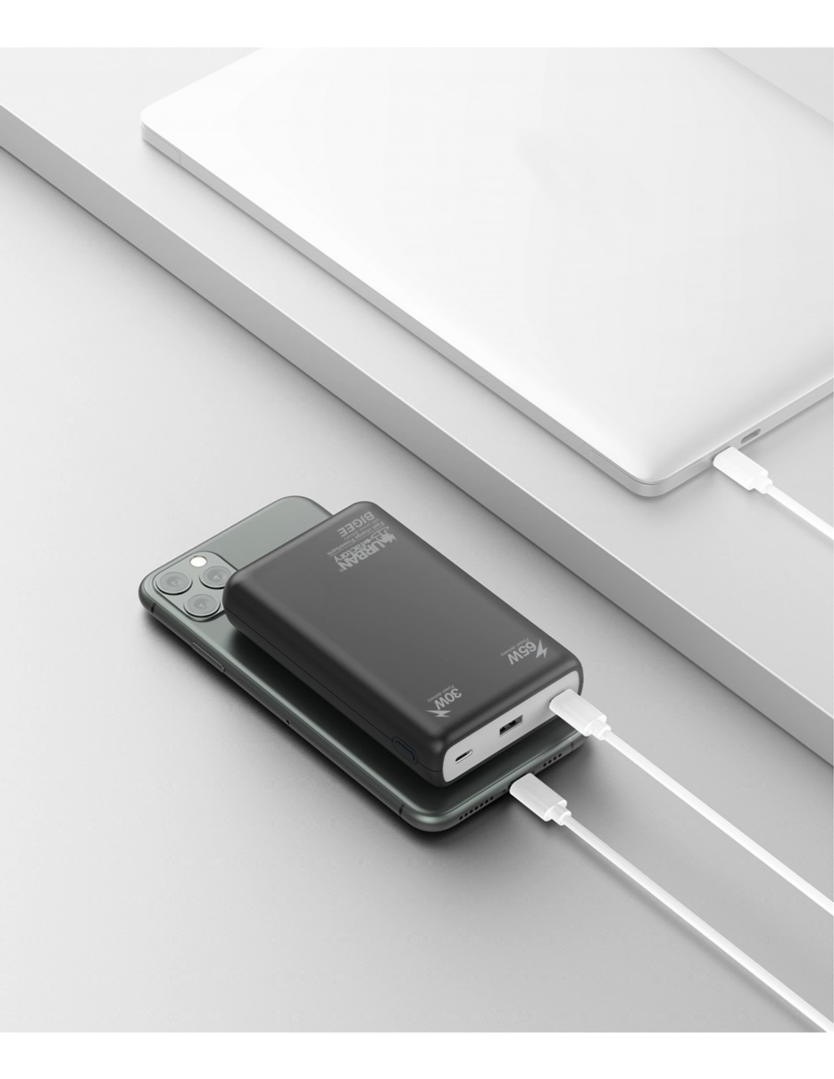 Telefono in carica con power bank e laptop. Entrambi hanno cavi bianchi.