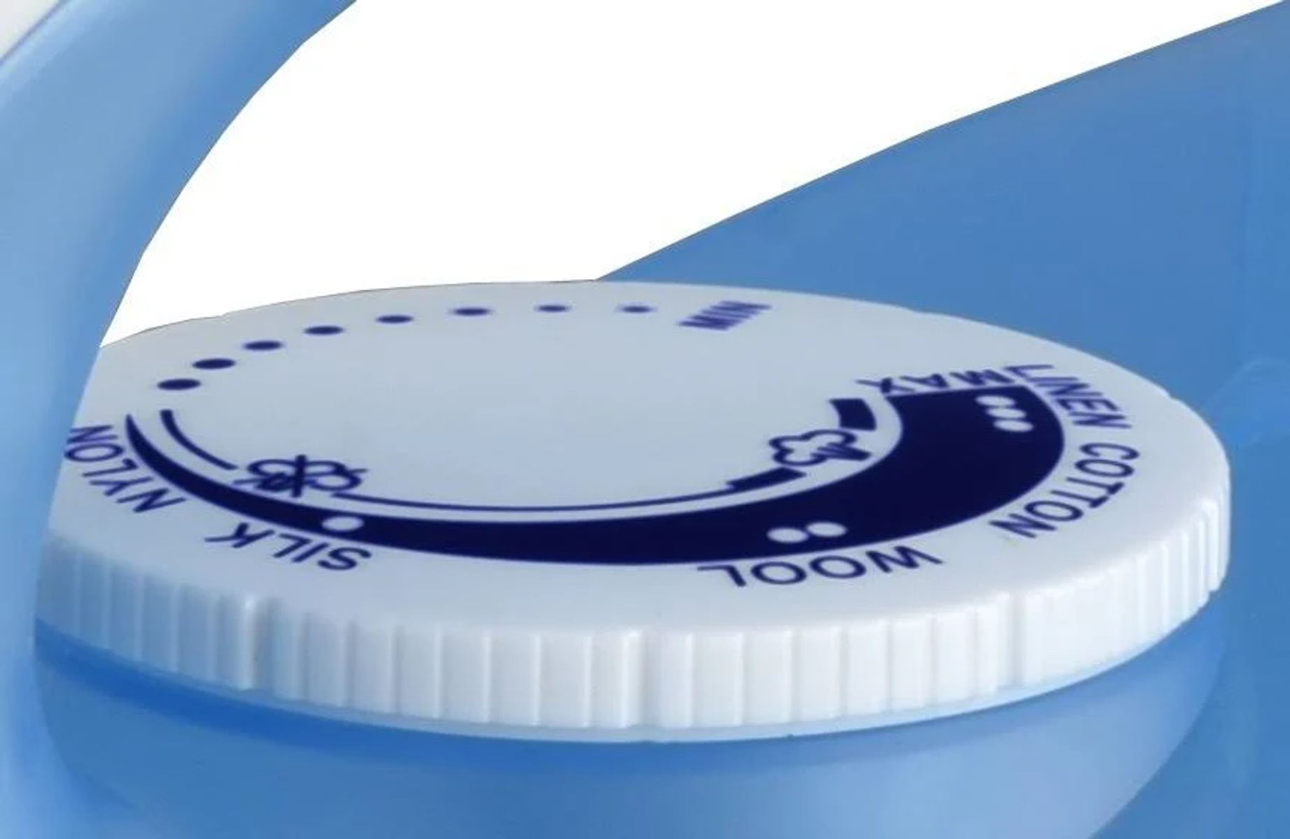 Nahaufnahme des Temperaturwählers eines Bügeleisens, mit Einstellungen für Seide, Nylon, Wolle, Leinen und Baumwolle.