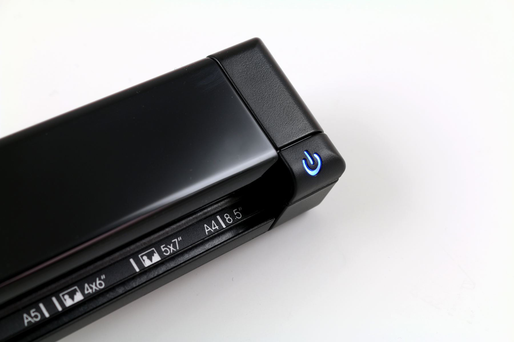 Schwarzer Scanner mit Ein- und Aus-Schalter. Zeigt Papierformatoptionen, A4, 5x7 und 4x6 Zoll.