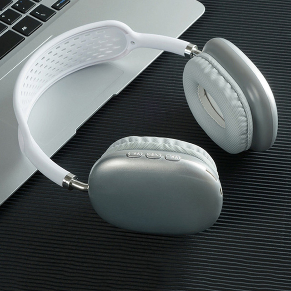 Auriculares blancos y grises sobre una superficie negra.