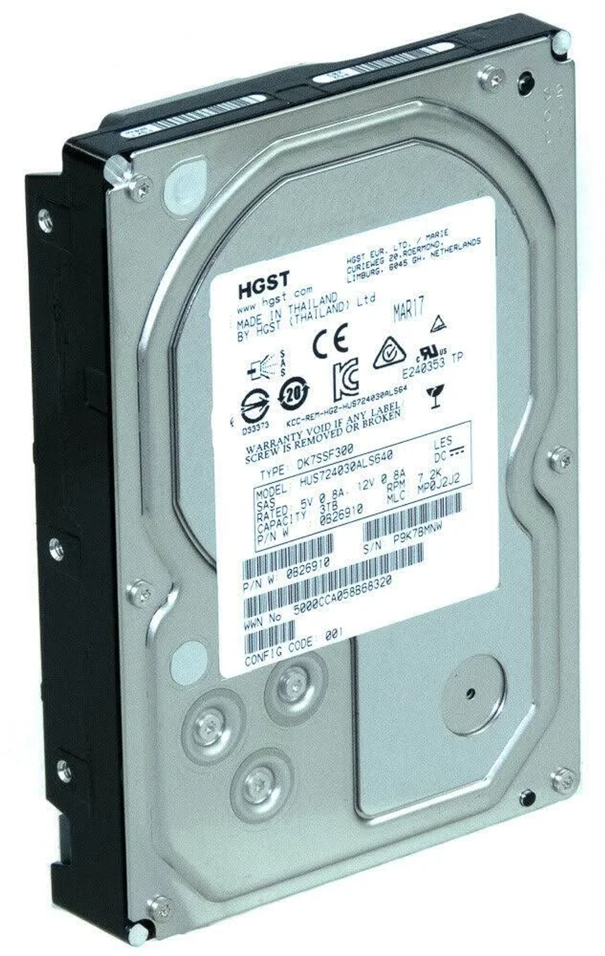 Dysk twardy z etykietami i metalową obudową, na jasnym tle, pokazujący szczegóły.