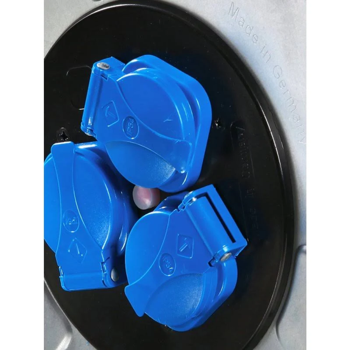 Drei blaue elektrische Stecker in einem schwarzen Kreis, vor weißem Hintergrund.