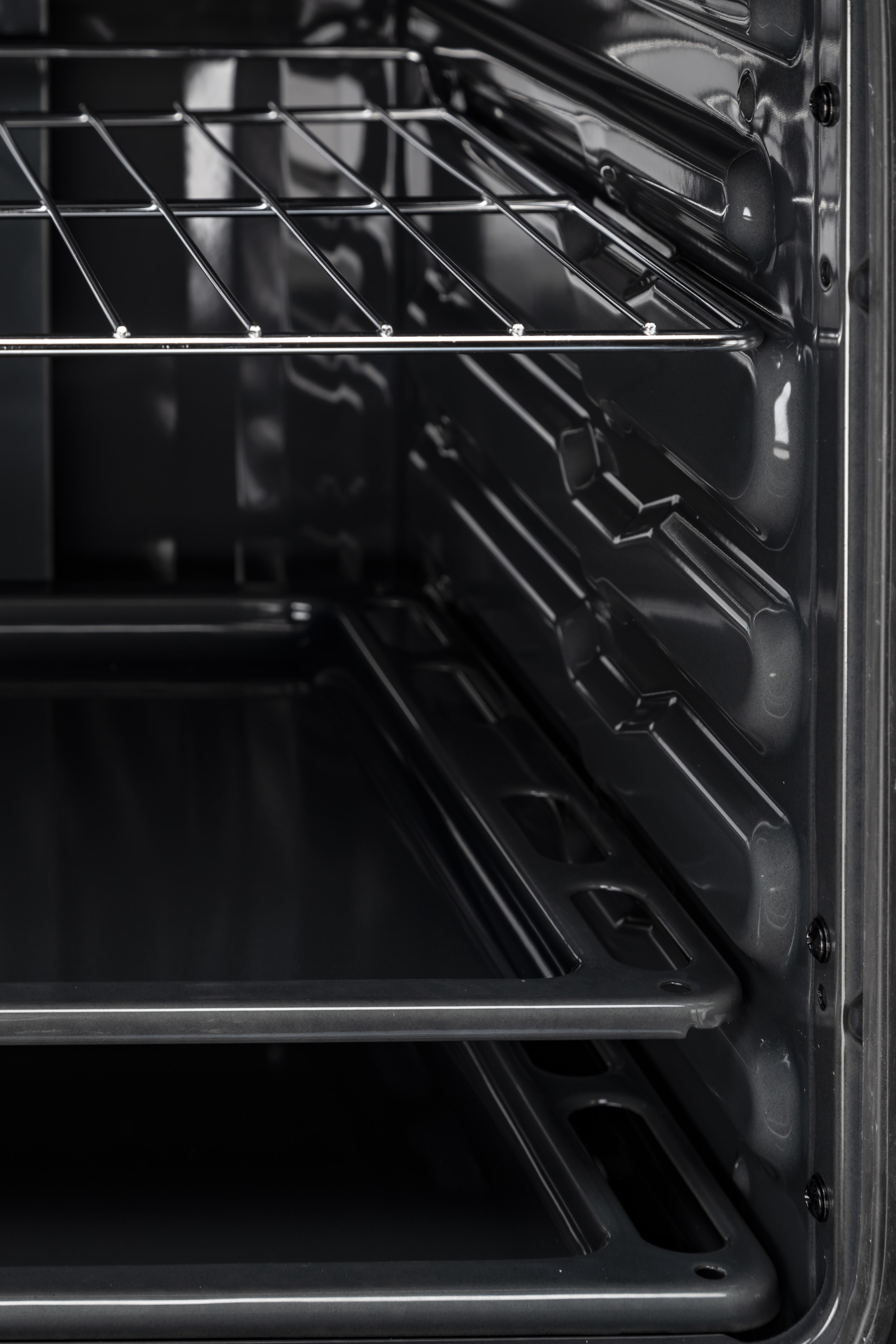 Un interior de horno que muestra estantes y un interior negro.