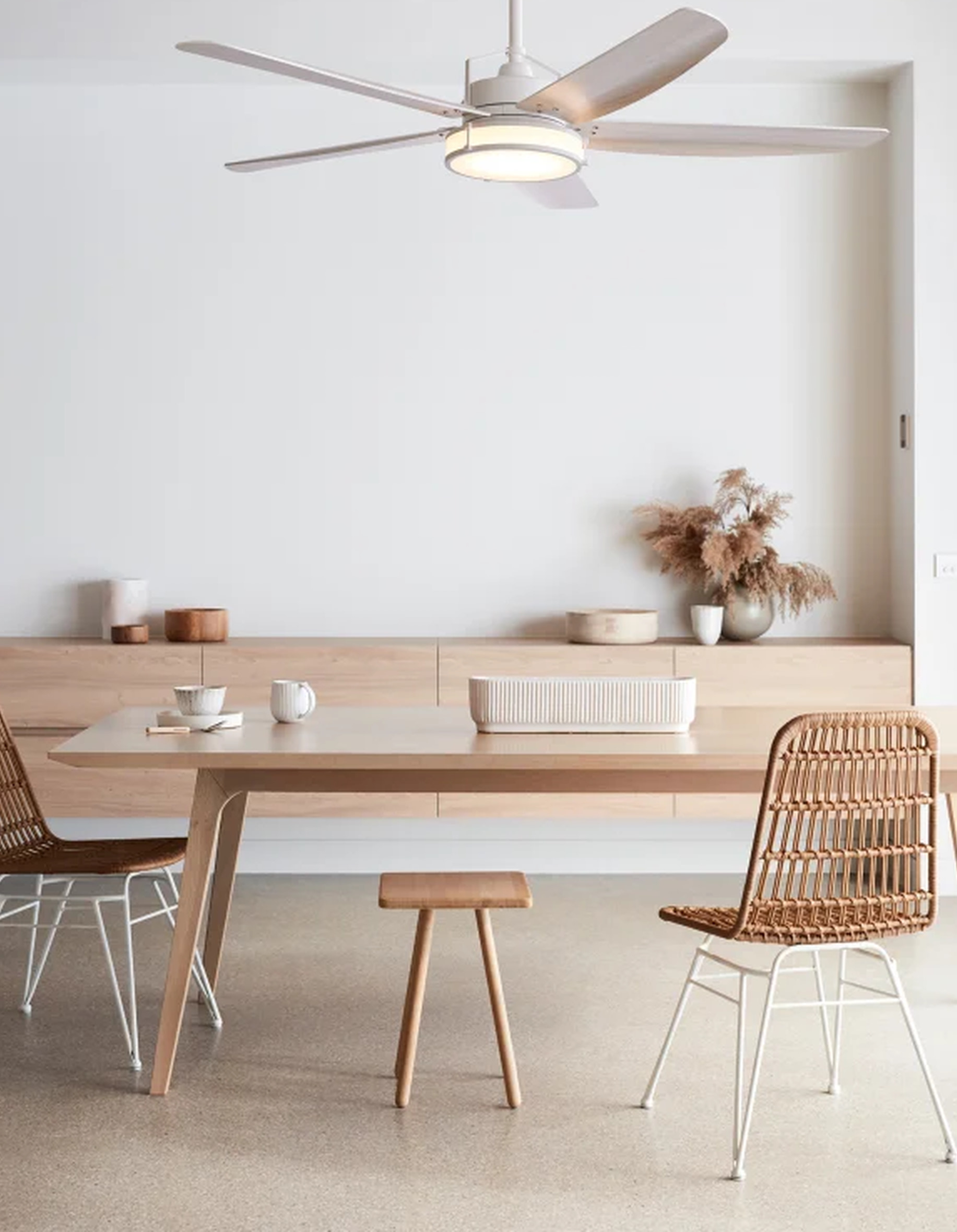 Esszimmer mit Tisch, Stühlen und Deckenventilator. Beige- und Weißtöne.