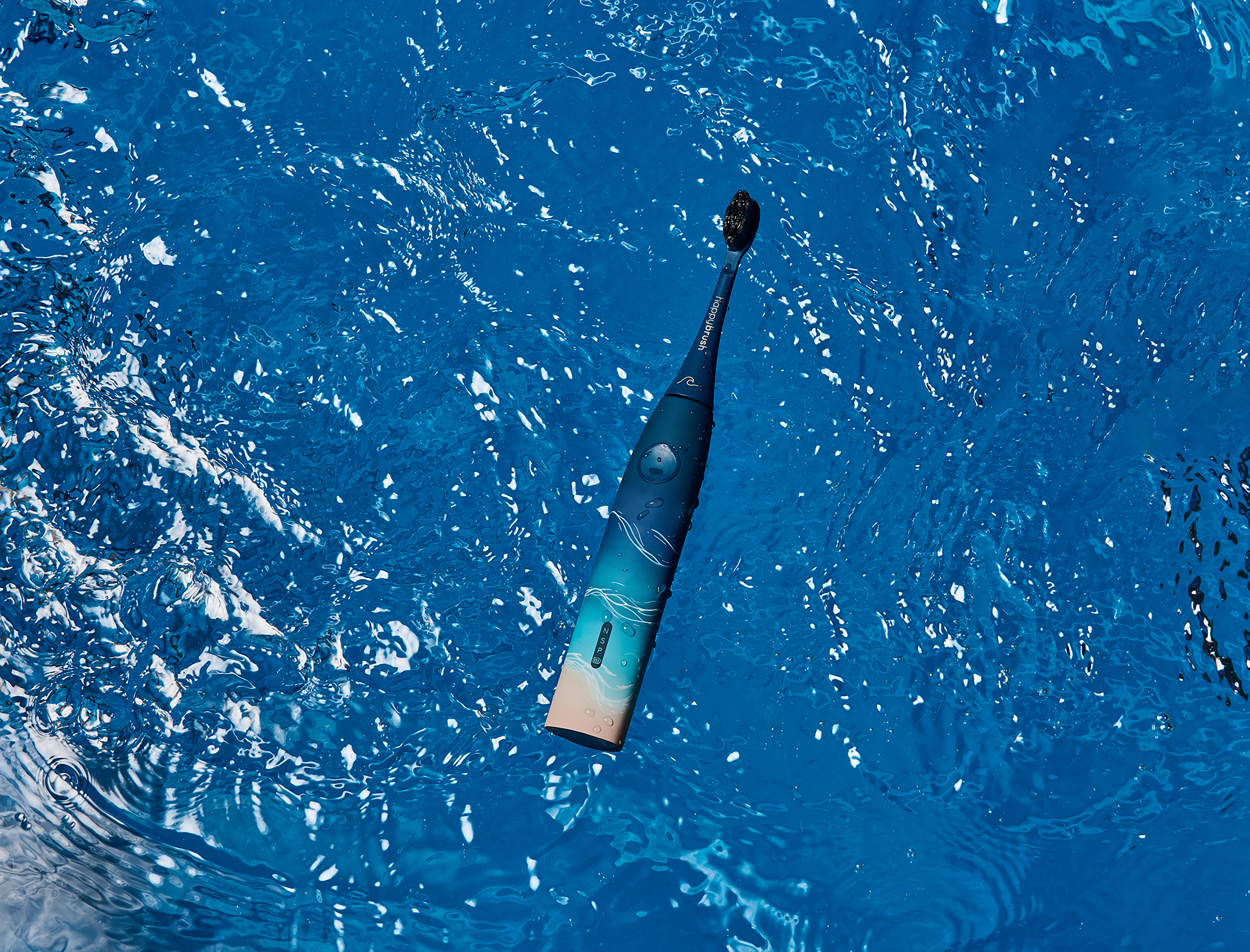Zahnbürste schwimmt in blauem Wasser, Nahaufnahme.