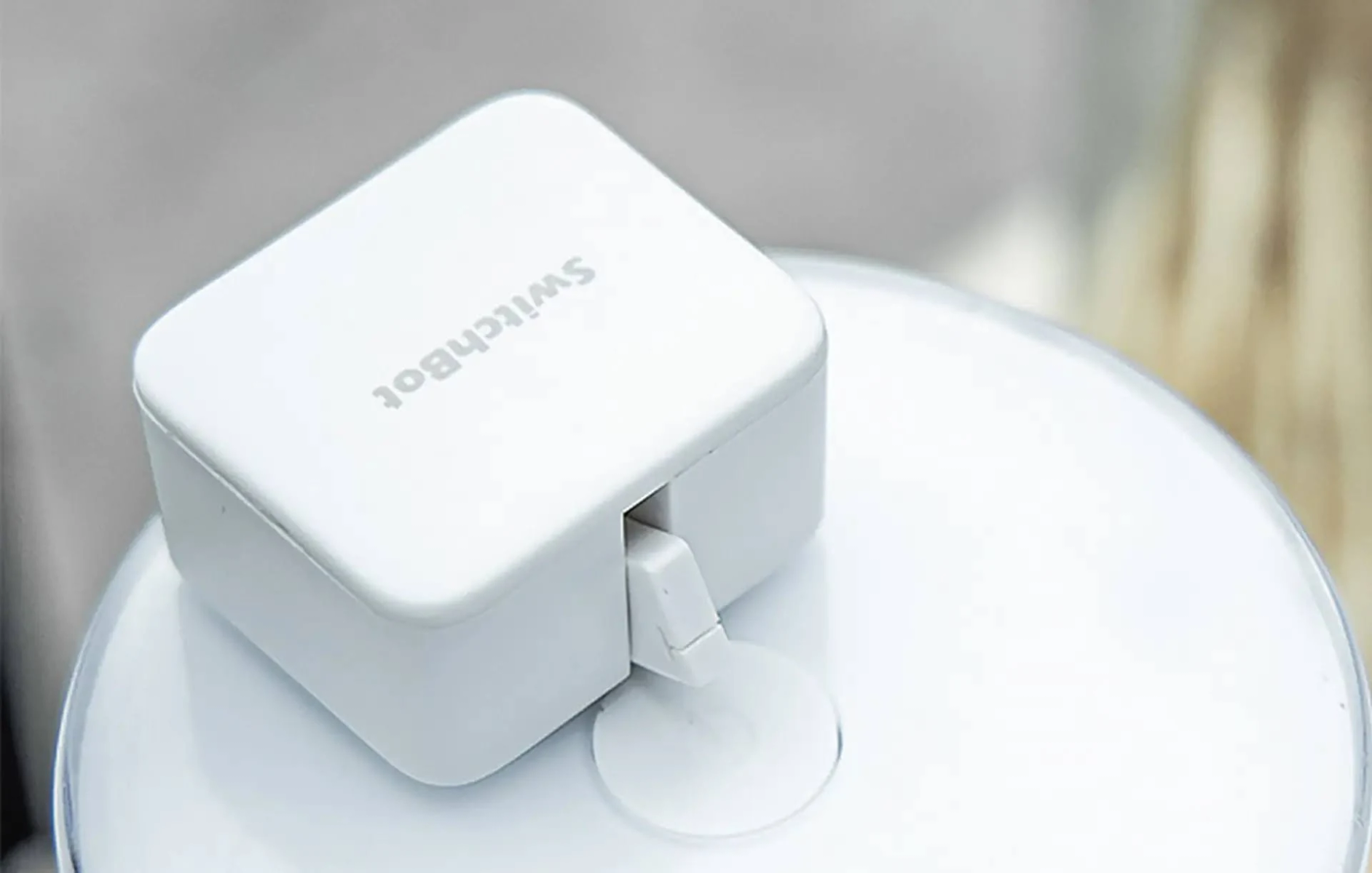 Dispositivo Switchbot bianco su una superficie bianca.