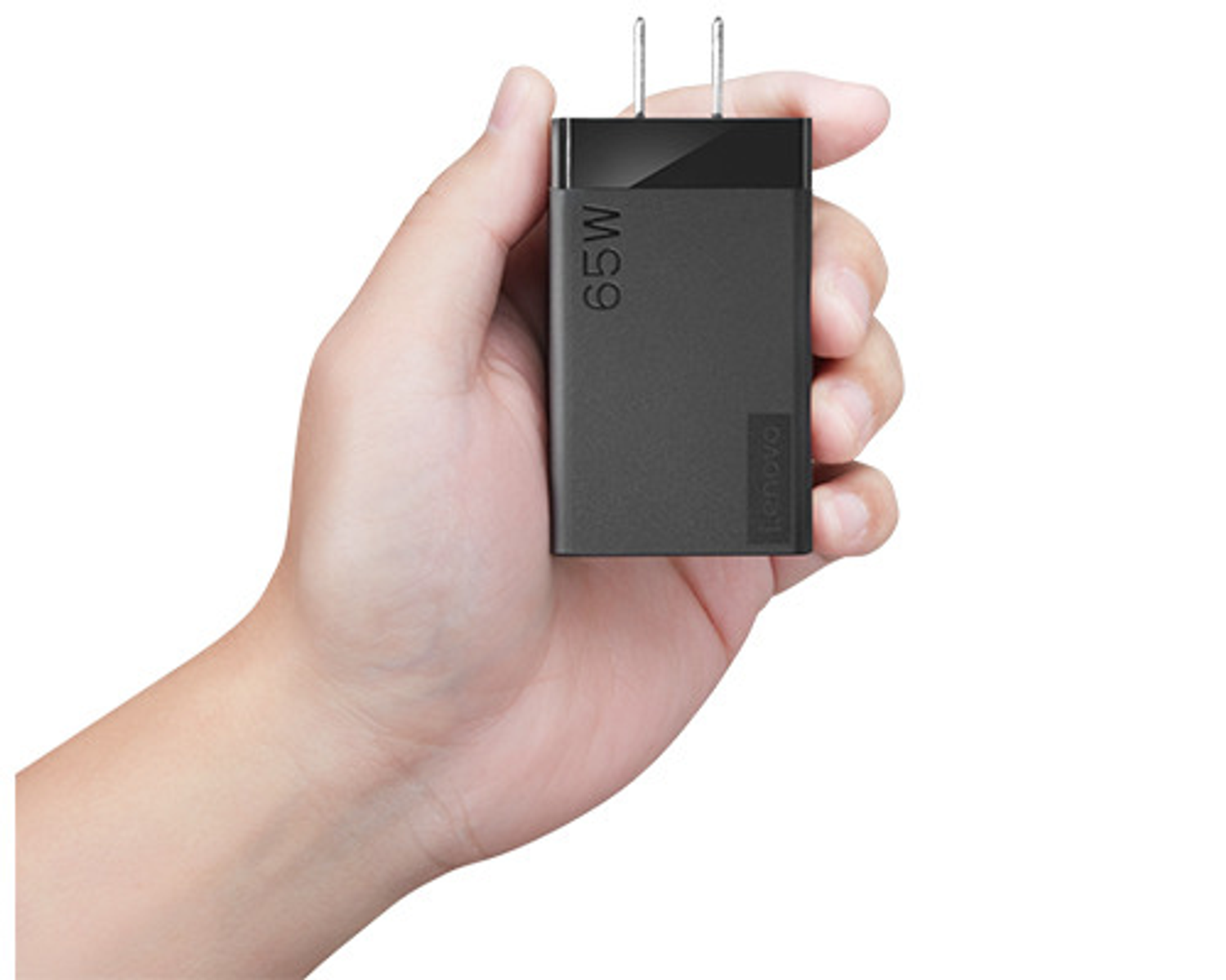 Eine Hand, die ein schwarzes 65-W-Lenovo-Ladegerät hält. Das Ladegerät hat einen Stecker.