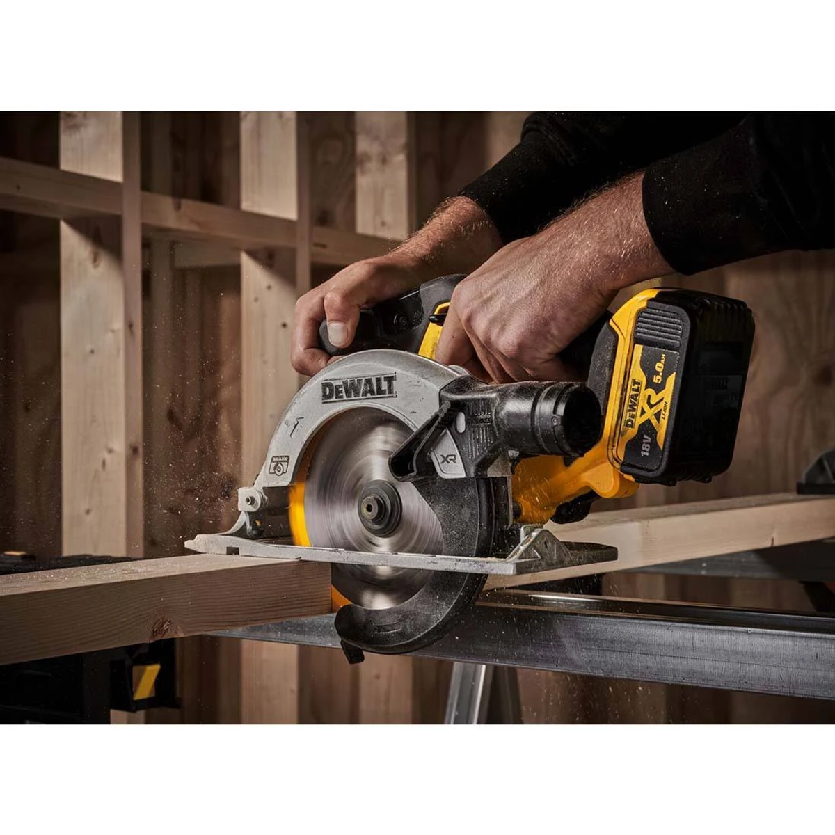 Mann benutzt DeWalt-Kreissäge. Schneidet Holz auf Arbeitsfläche. Schwarze und gelbe Säge.