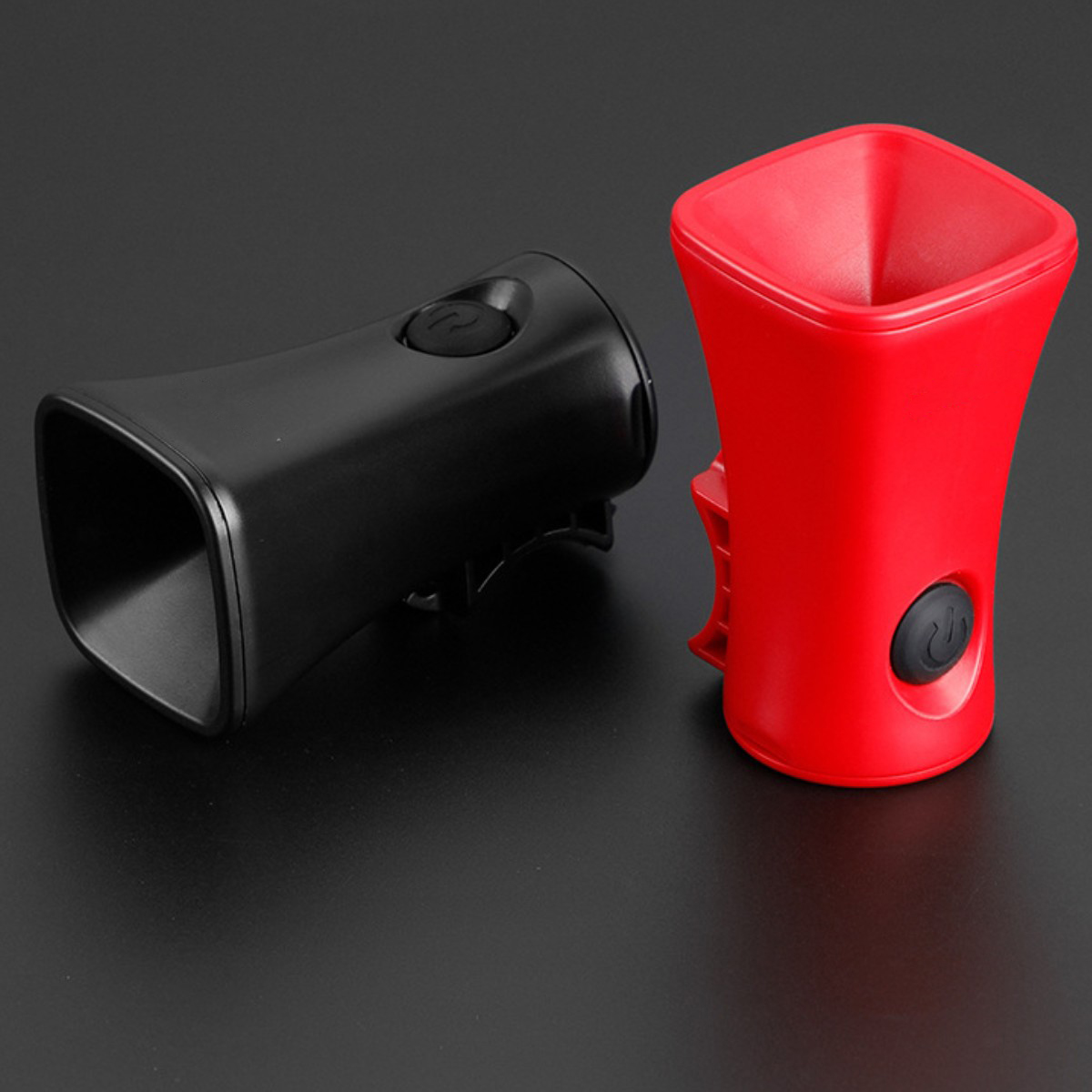 Dos altavoces negros y rojos con un botón de silencio.