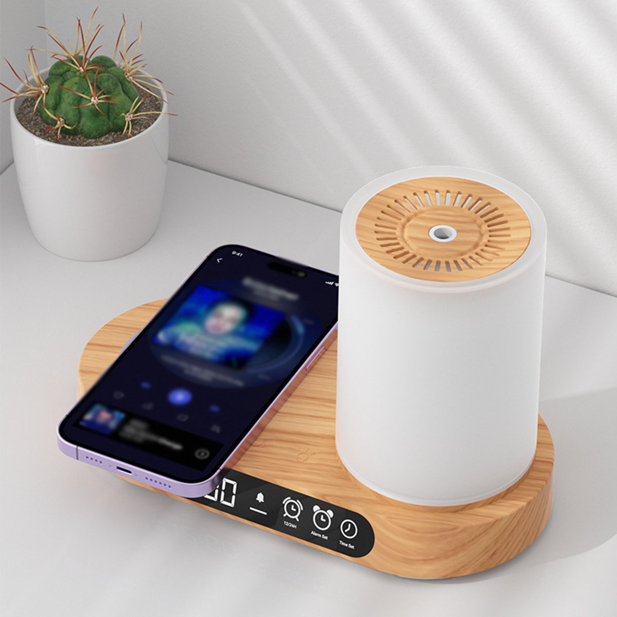 Ein Telefon auf Holzsockel, ein weißer Diffusor und eine Pflanze stehen auf weißer Oberfläche.