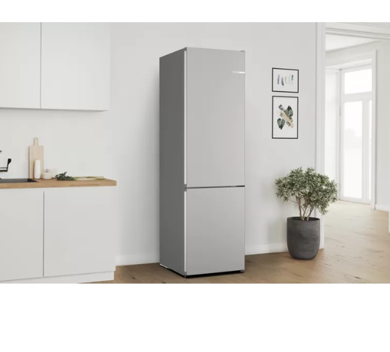 Ein hellgrauer Kühlschrank in einer modernen Küche. Es hat zwei Türen.