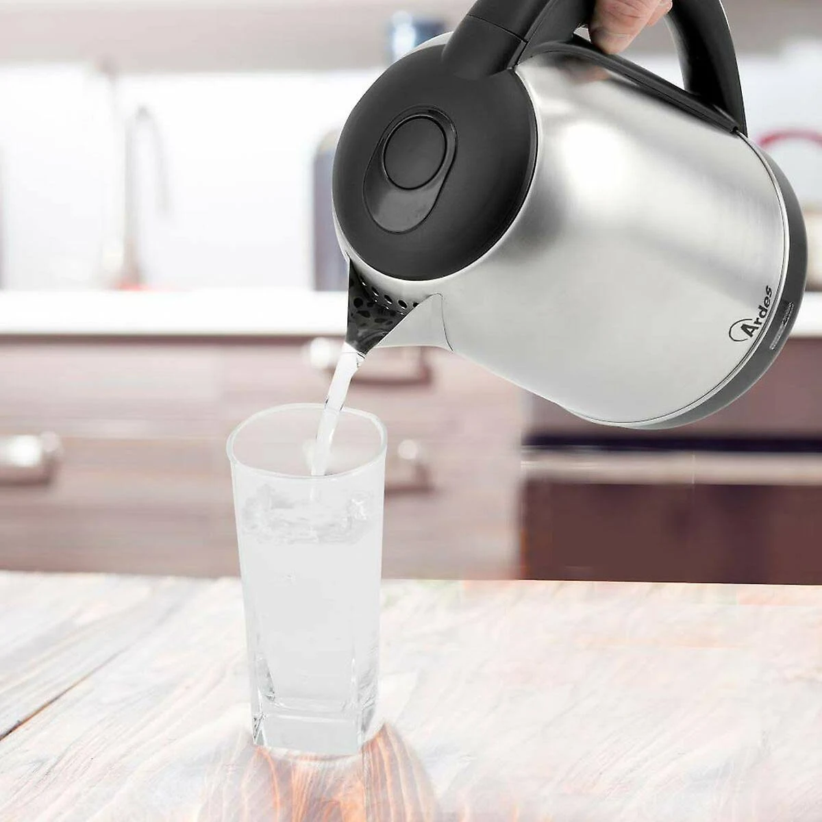 Czajnik ze stali nierdzewnej nalewający wodę do szklanki.