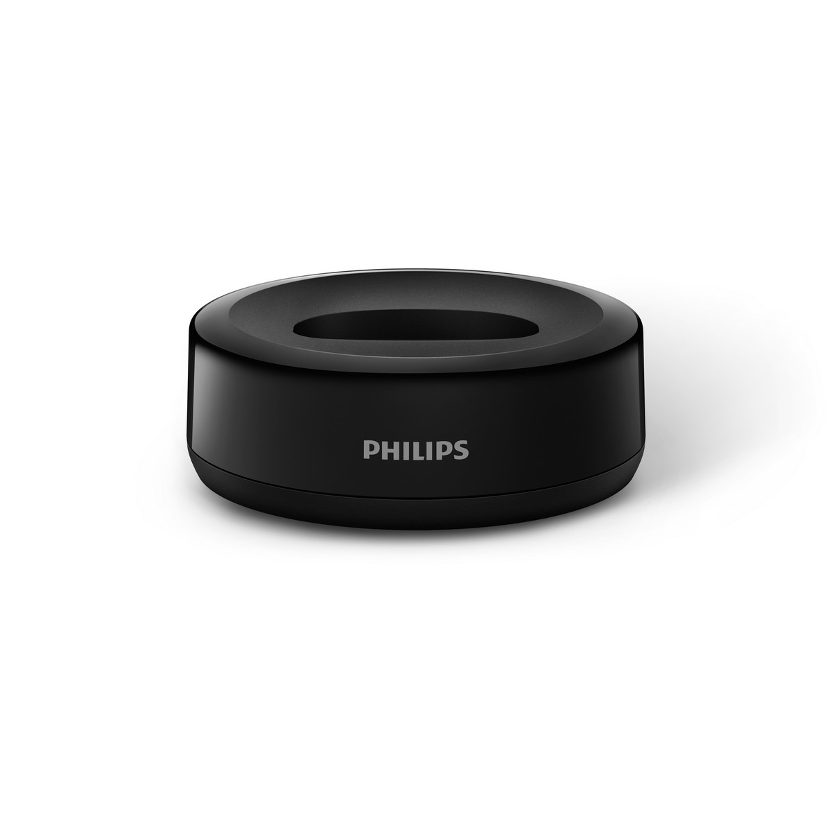 Una base di ricarica cilindrica nera con il marchio 'PHILIPS' sul davanti.