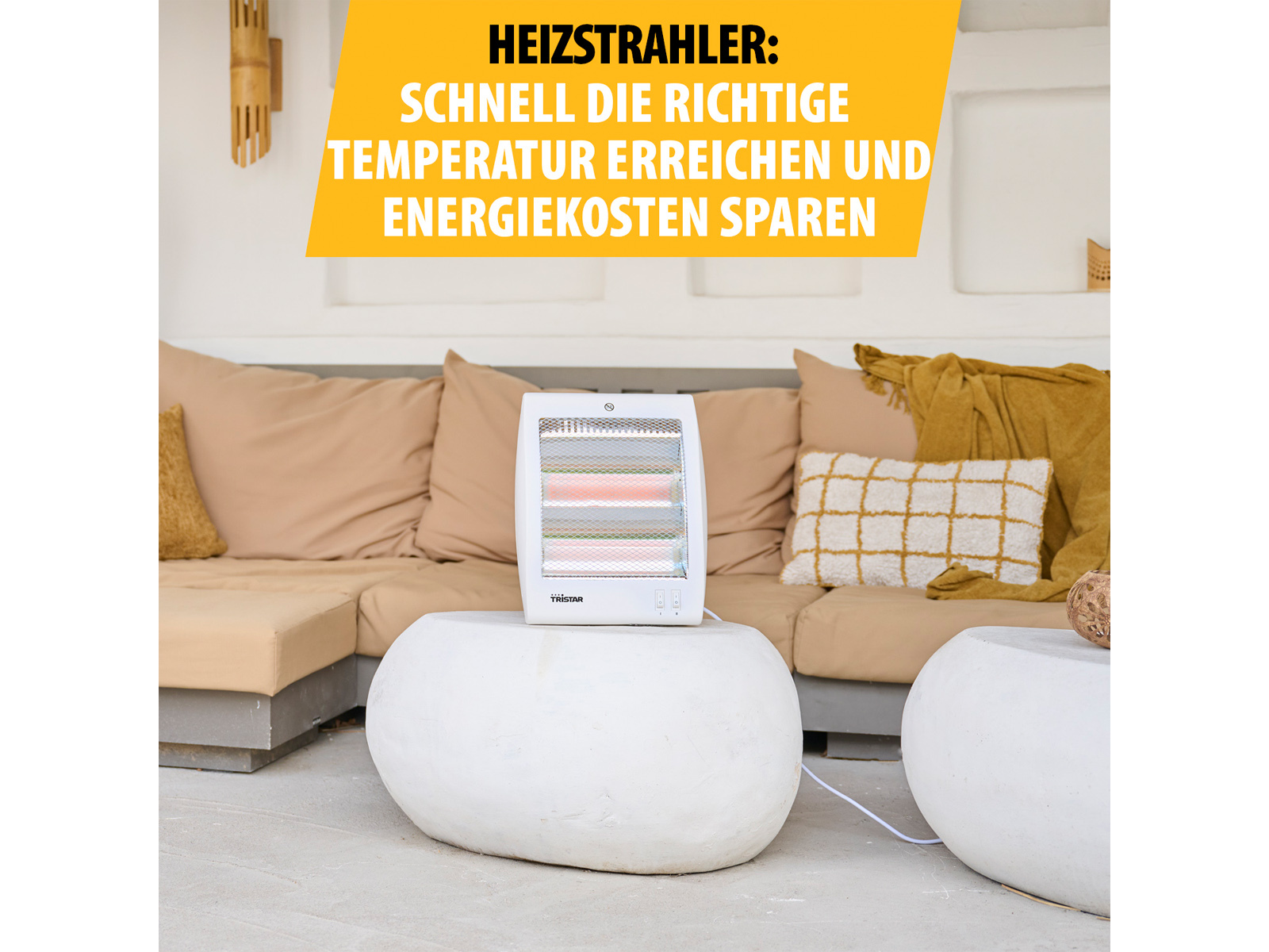 Ein weißer Heizlüfter steht auf einem weißen Tisch. Im Hintergrund befinden sich eine Couch und Kissen.