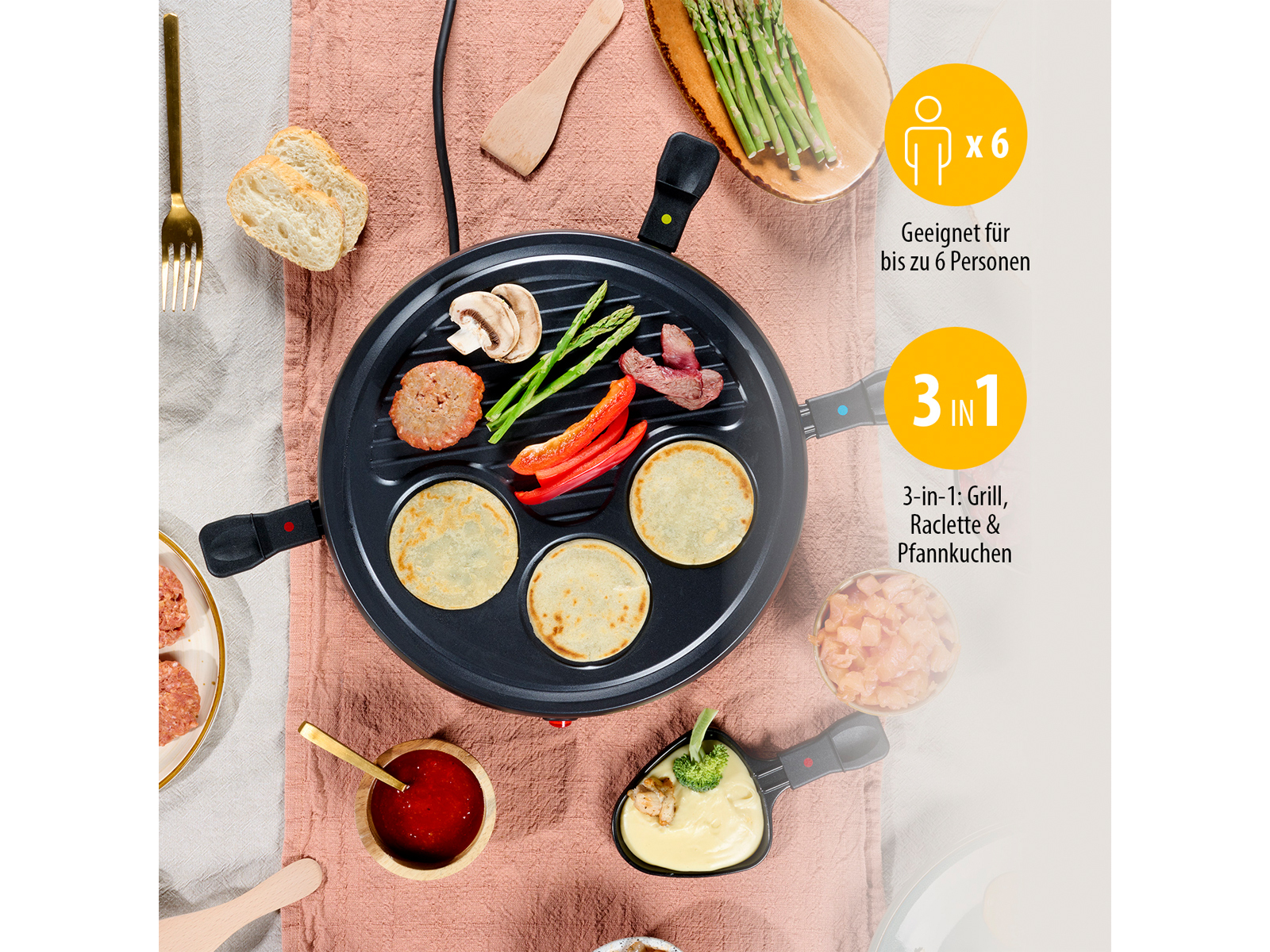 Raclette-Grill mit Essen, darunter Pfannkuchen, Gemüse und Fleisch, auf einem Tisch.