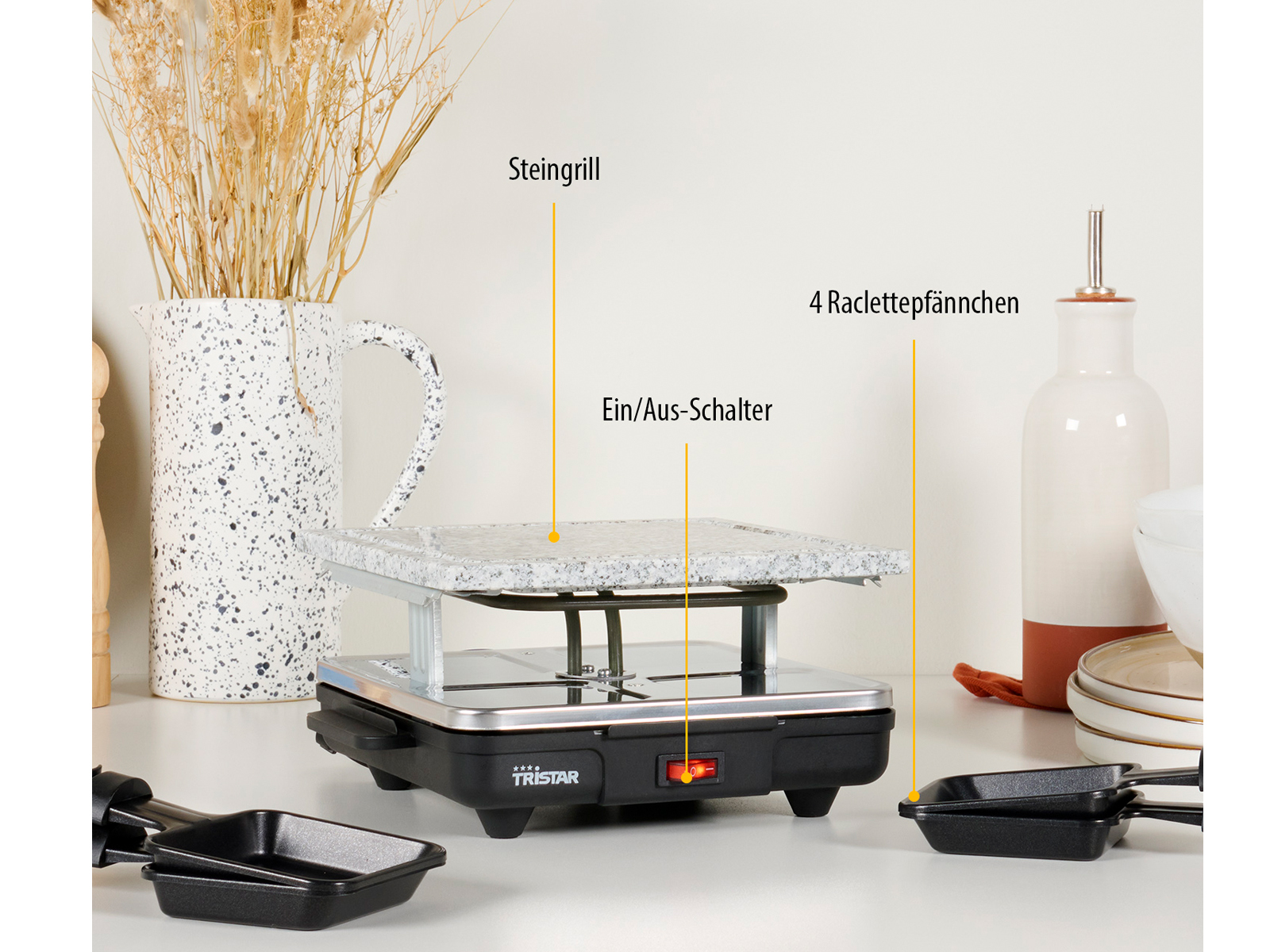 Raclette-Grill mit Käsepfannen und Dekorationen. Weißer Hintergrund.