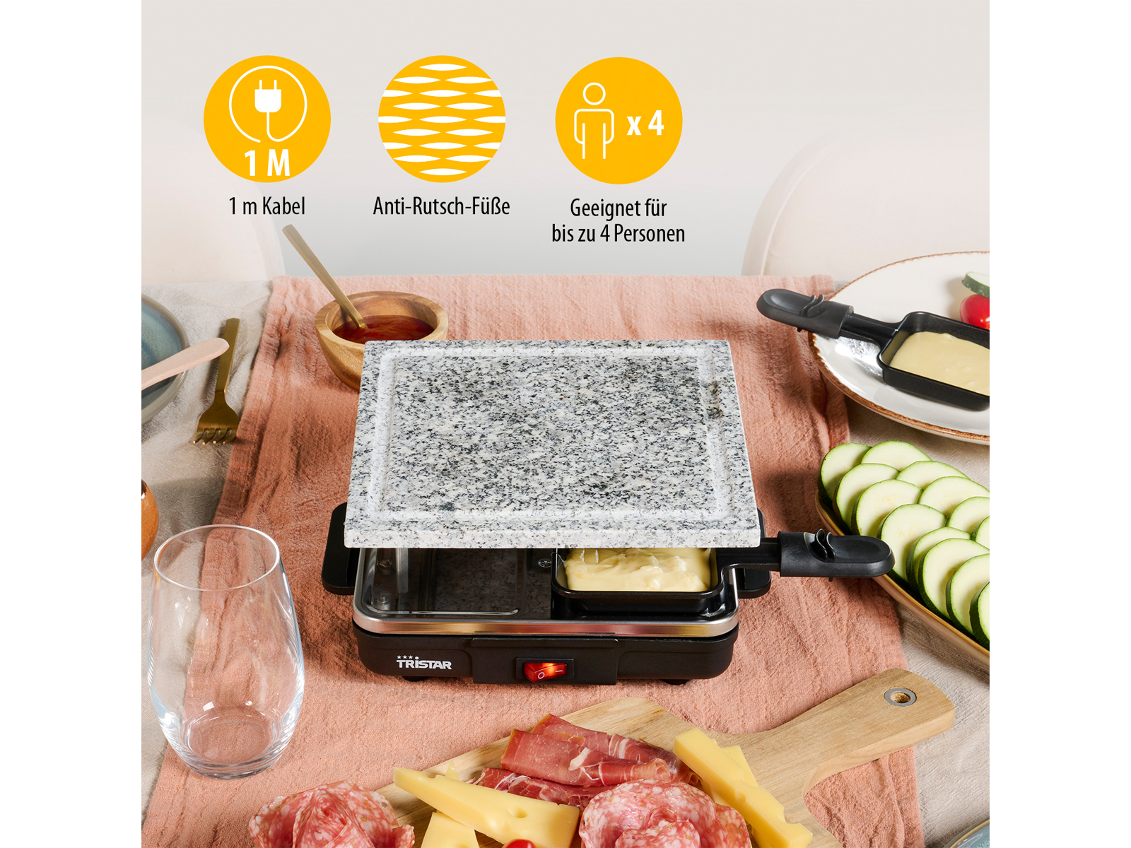 Ein Raclette-Grill mit Essen. Es hat eine Steinplatte und Zutaten. Auf einem Tisch.