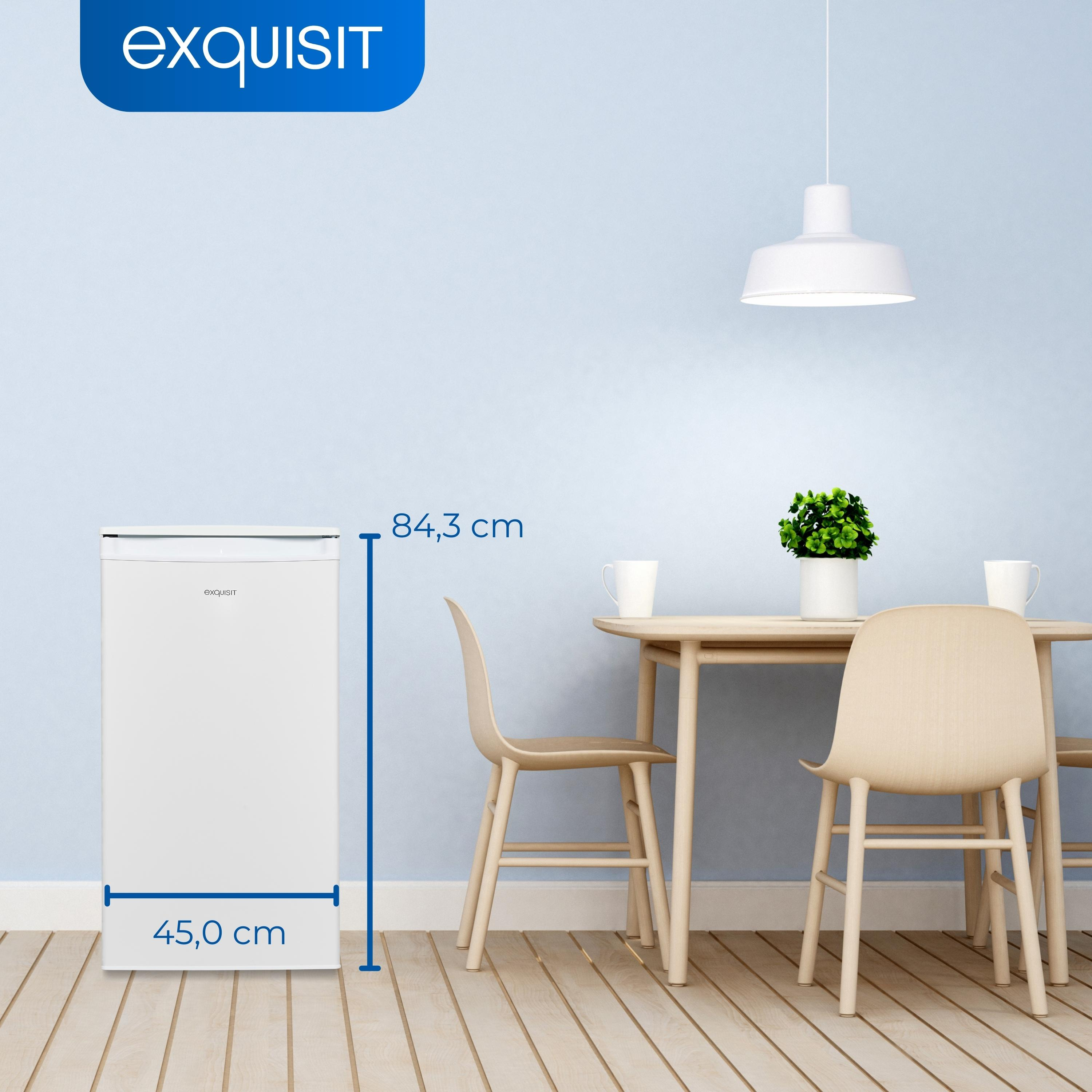 Weißer Kühlschrank neben einem Esstisch mit Stühlen in einem blauen Raum.