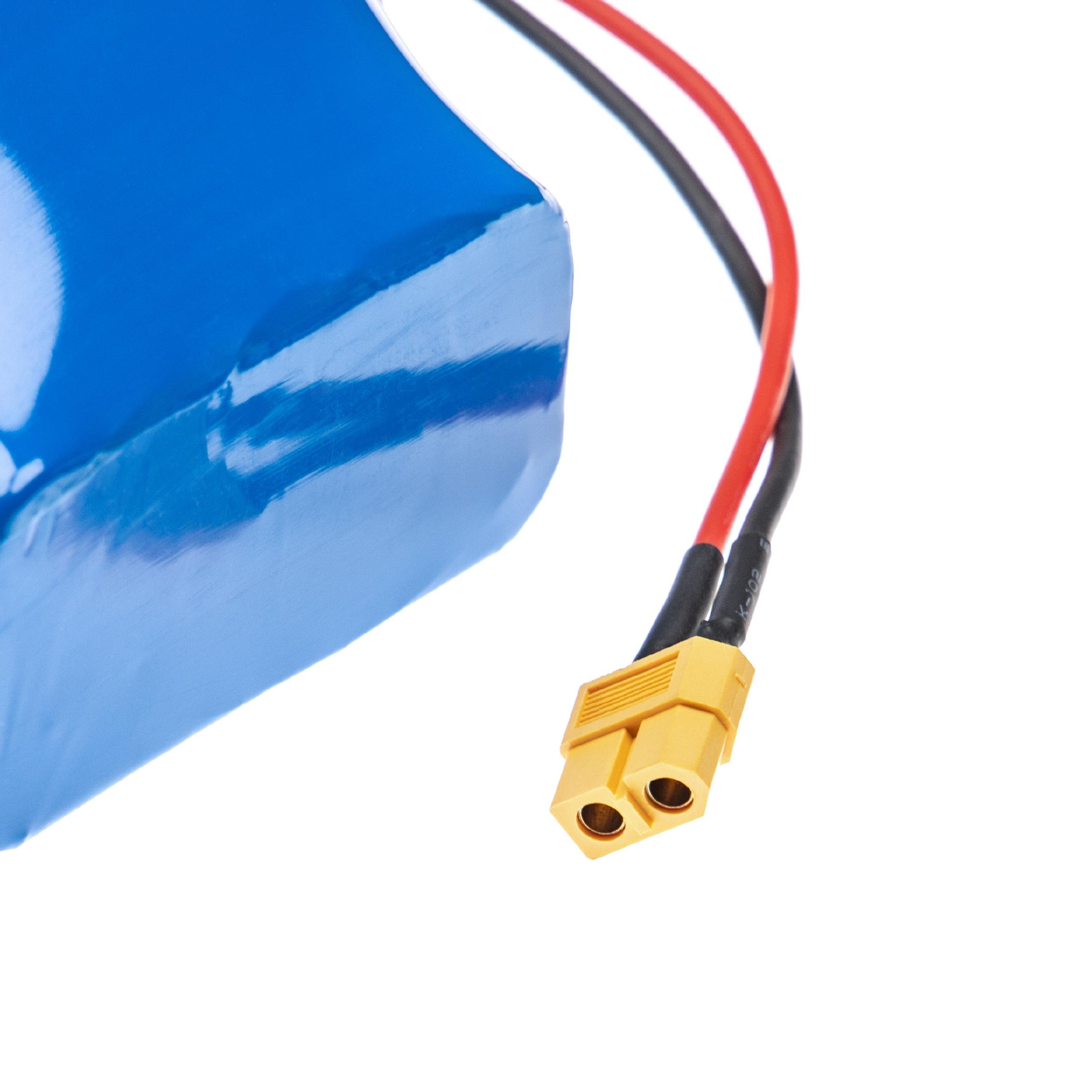 Blauer Akku mit roten und schwarzen Kabeln, die mit einem gelben Stecker verbunden sind. Weißer Hintergrund.