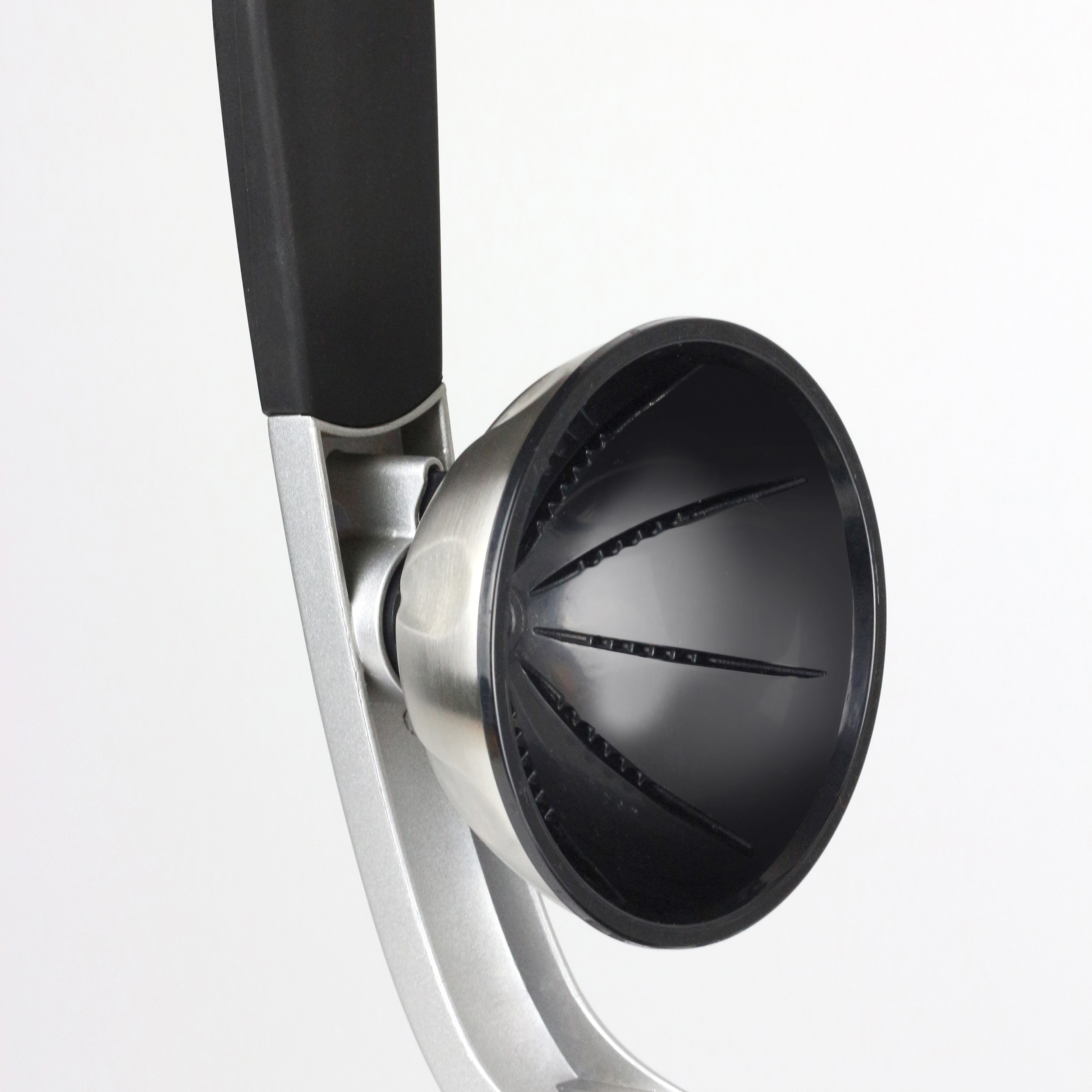 Primo piano di uno schiaccianoci con interno nero ed esterno metallico su sfondo bianco.