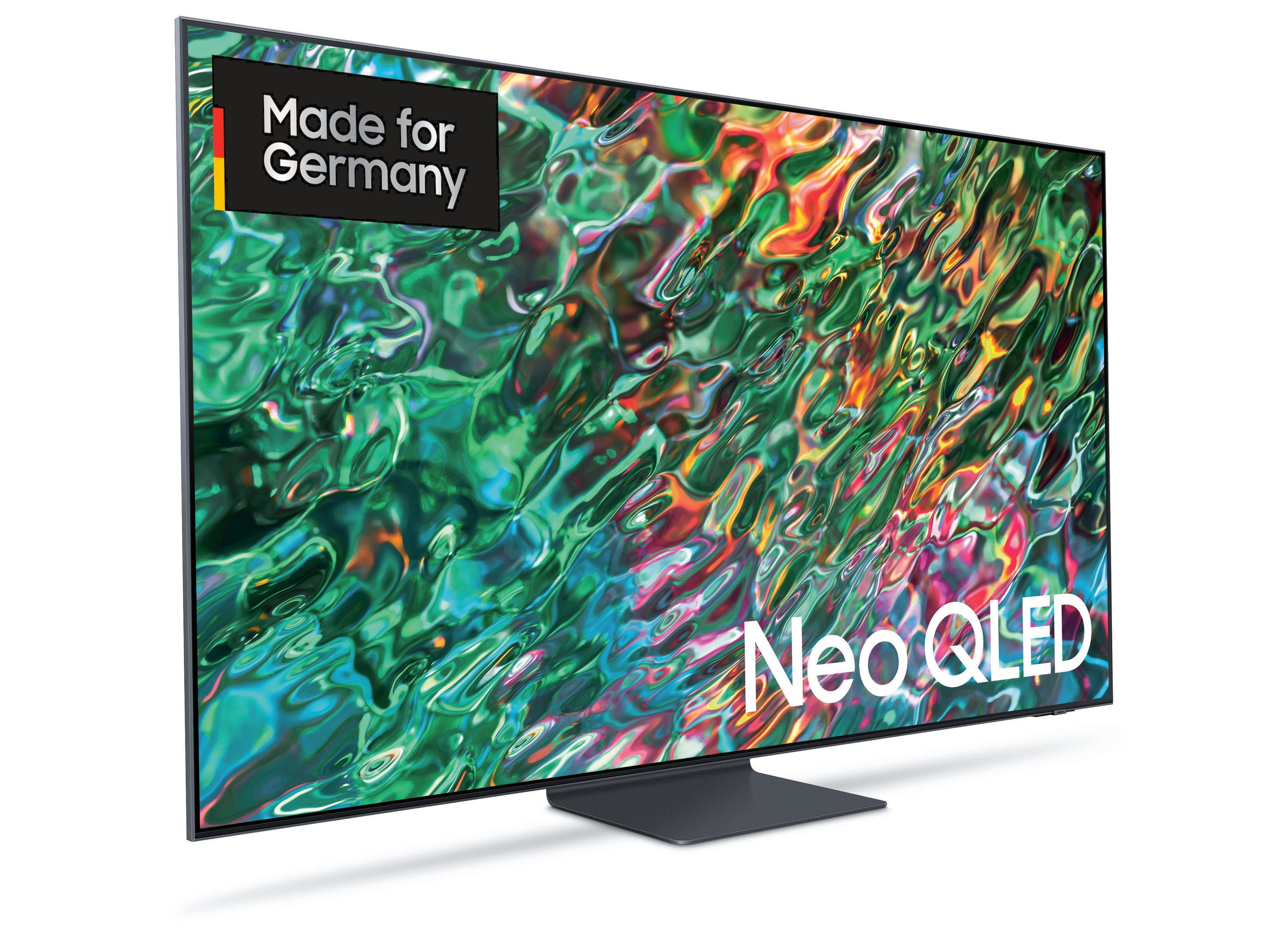 Duży telewizor z żywym ekranem. Naklejka "Made for Germany". Białe tło.